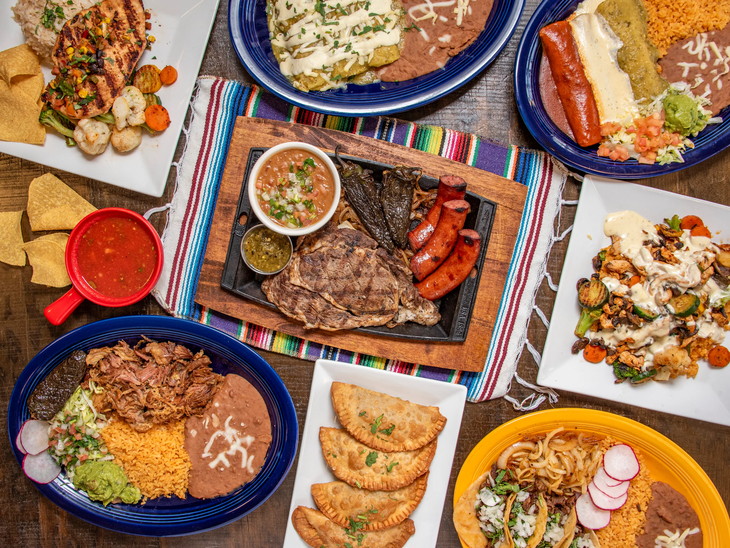 Colorful Mexican feast with tacos, enchiladas, and grilled meats
