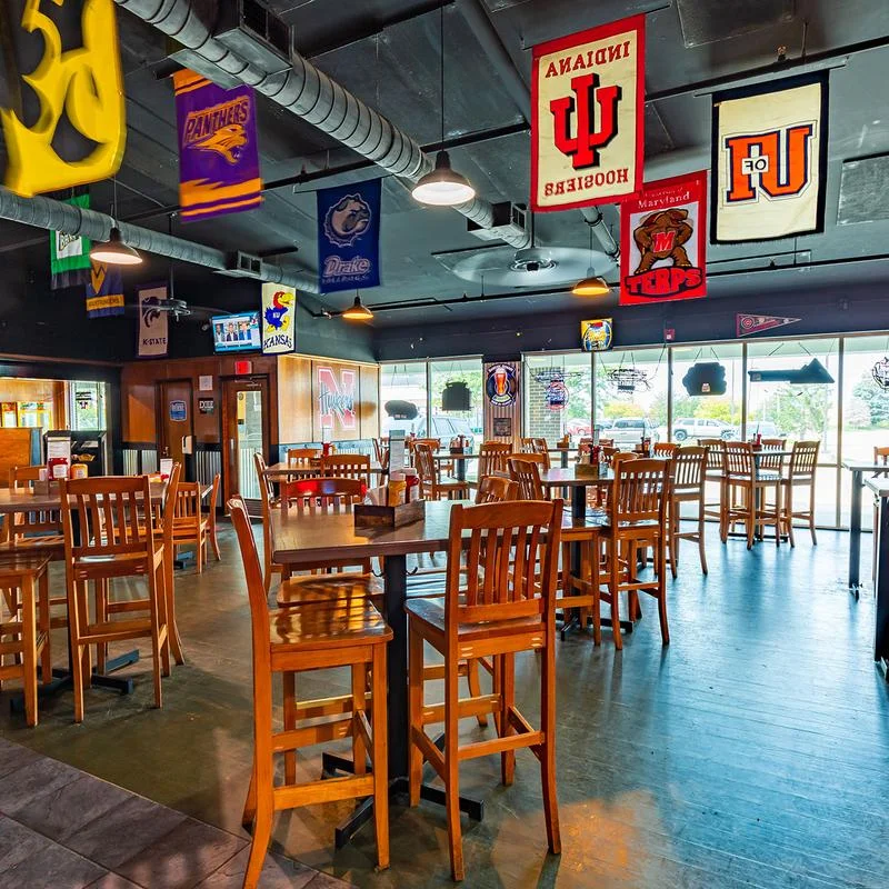 Cozy sports bar interior with wooden tables and team banners
