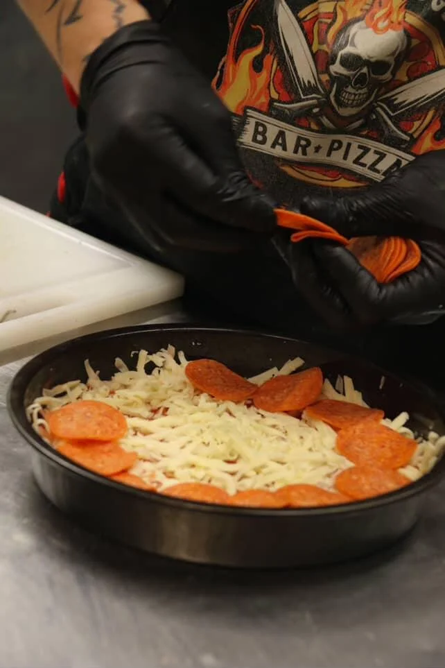 Preparing a classic pepperoni pizza in a deep dish style