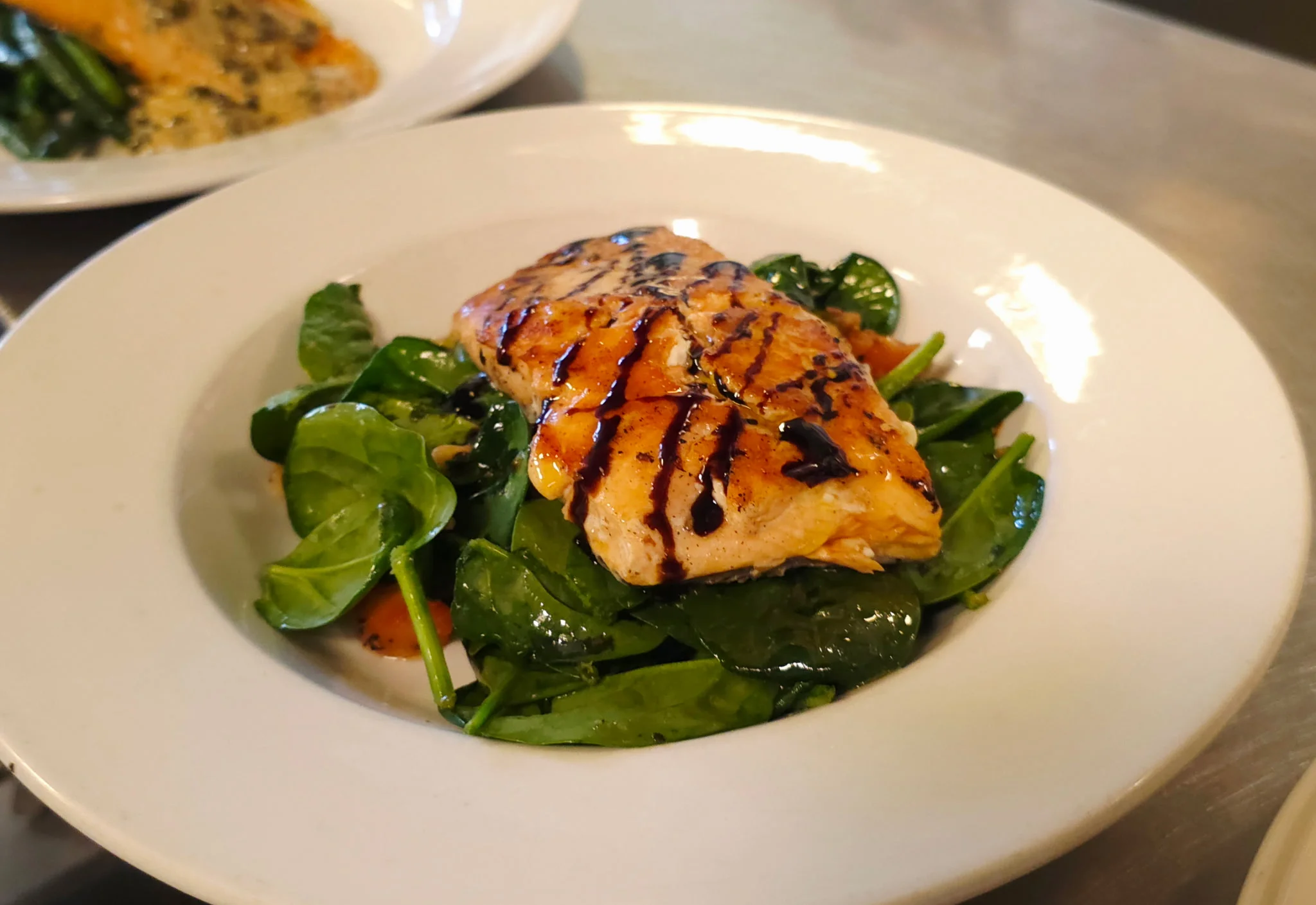 Grilled salmon on a bed of fresh spinach salad