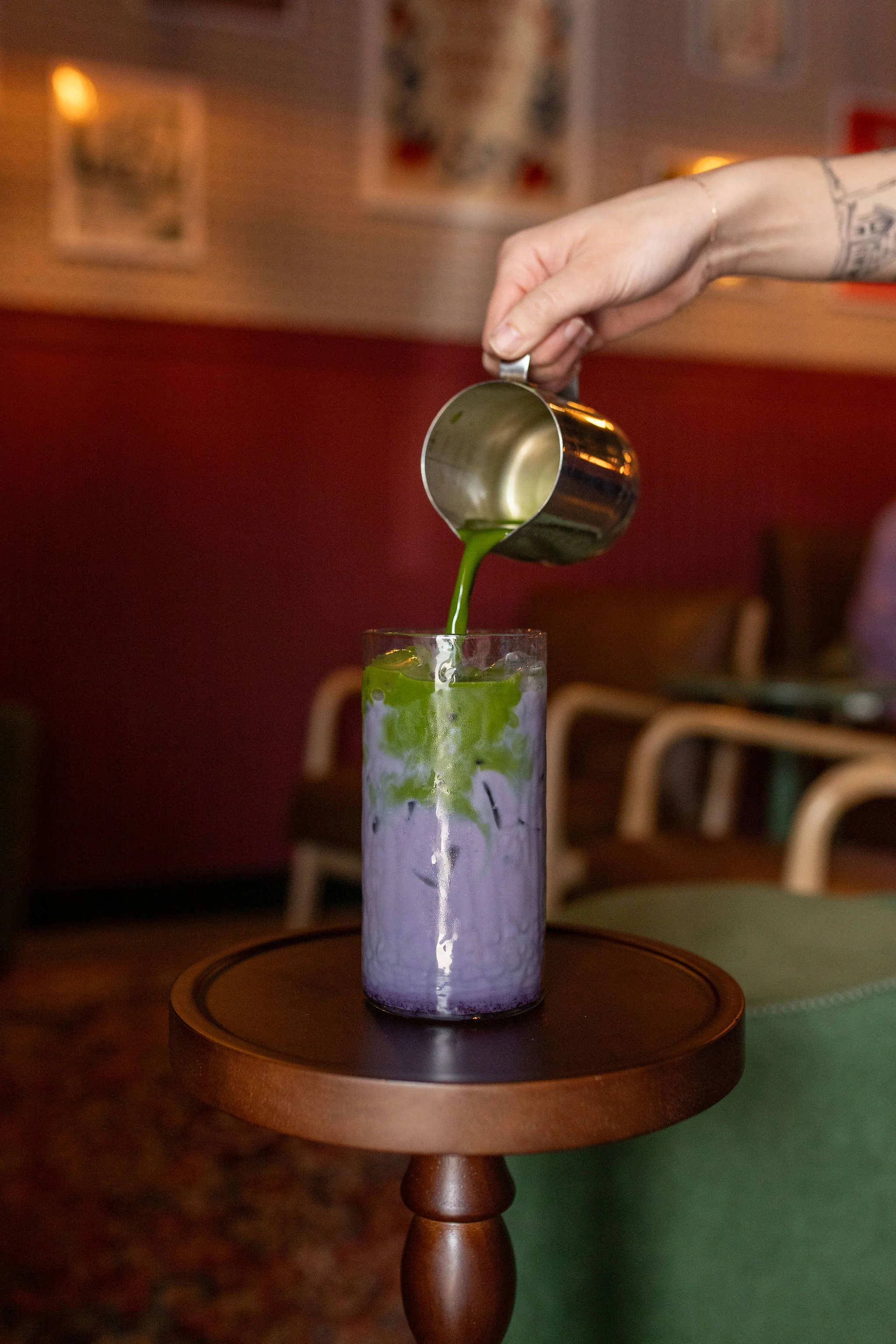 Pouring matcha over purple taro drink