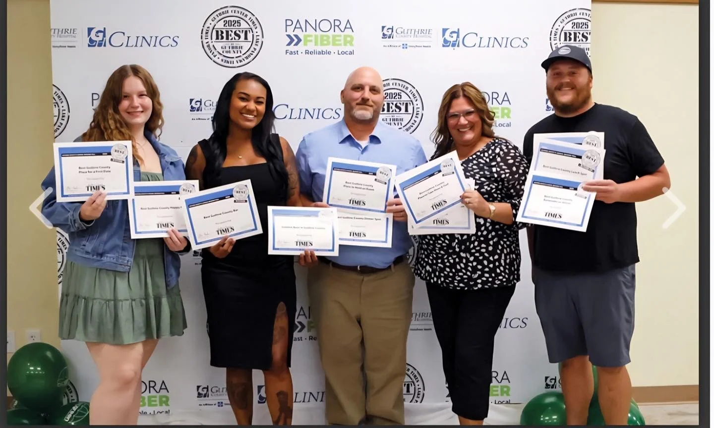 Group of award winners holding certificates at a local event