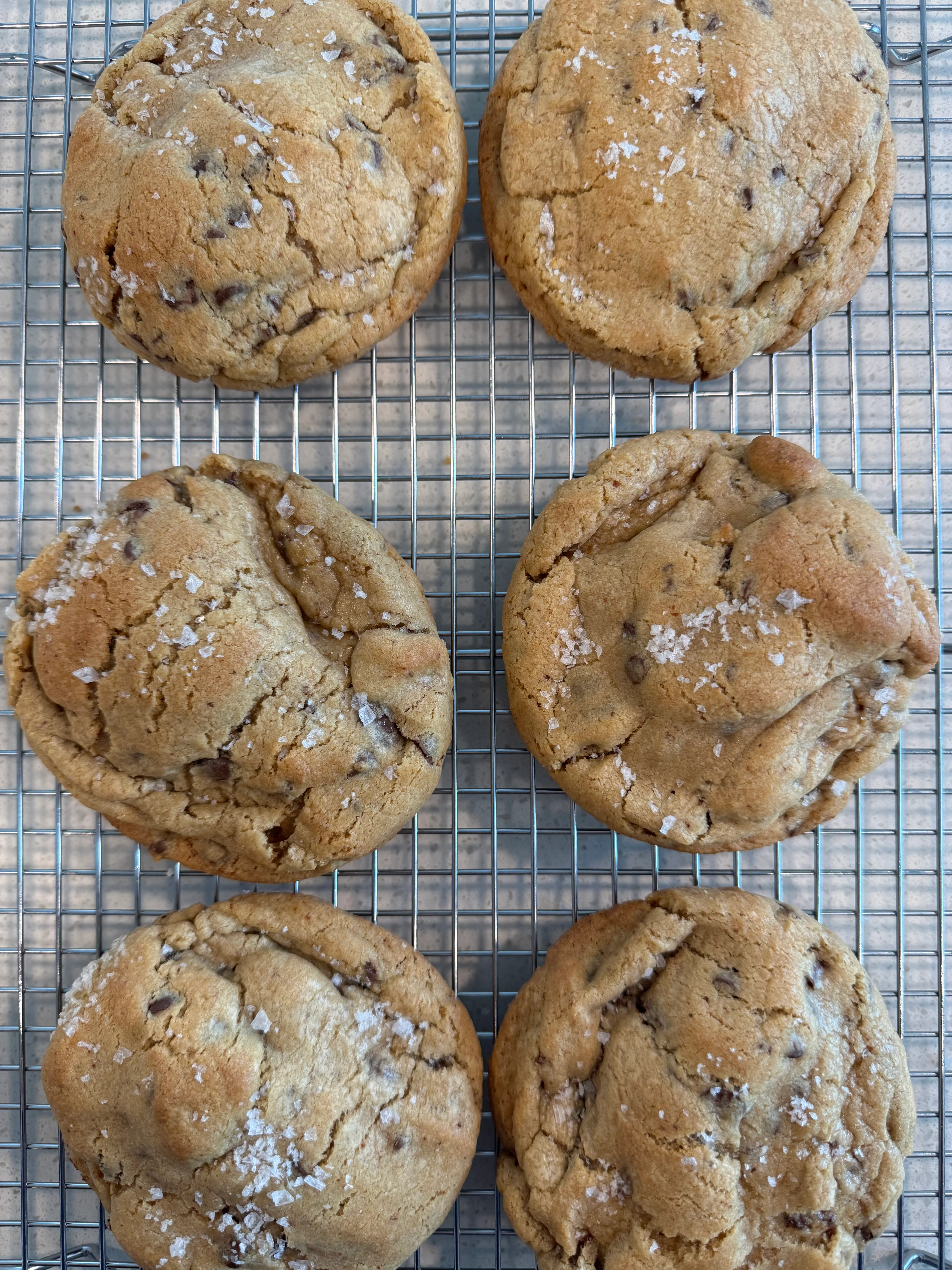 Freshly baked chocolate chip cookies on a wooden board