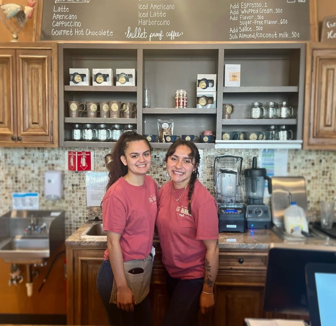 Baristas smiling in a cozy coffee shop
