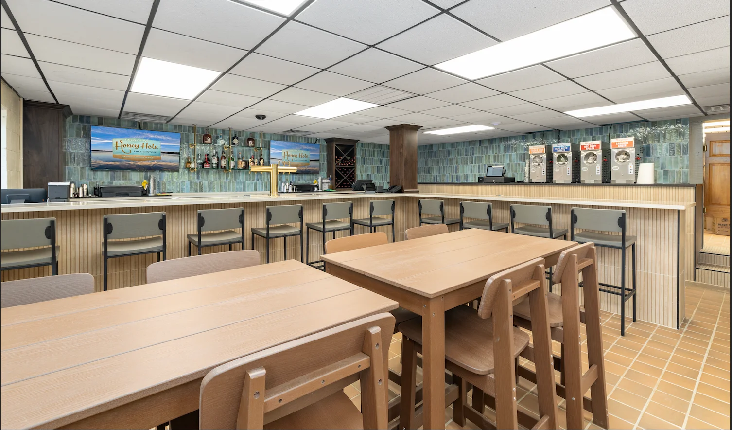 Interior view of a bar with seating and a variety of drinks displayed.