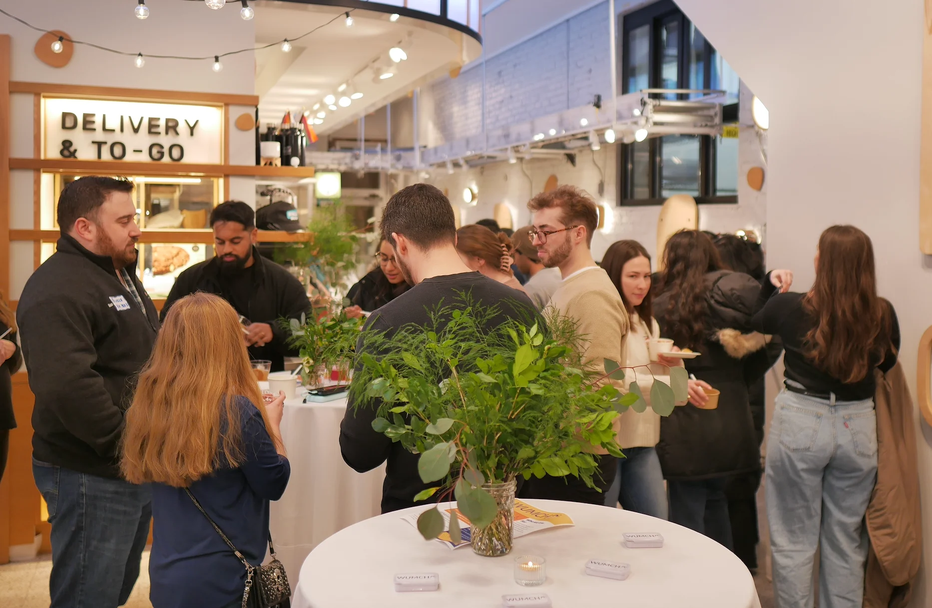 Social gathering in a modern restaurant with plants and casual dining atmosphere