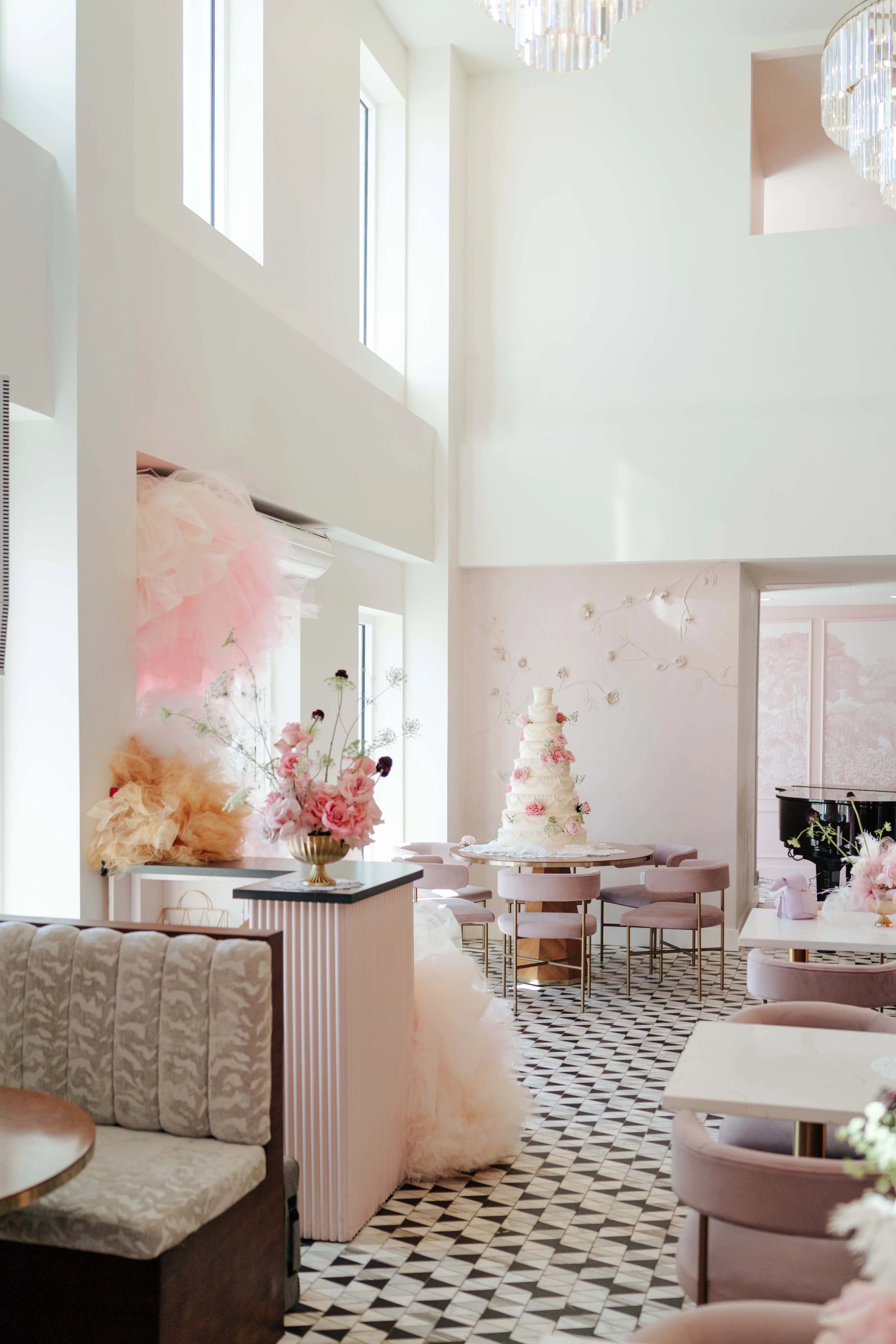 Elegant restaurant interior with pink decor and a wedding cake centerpiece