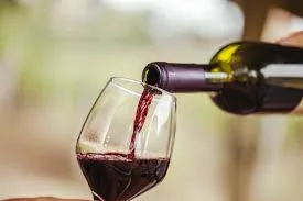 Pouring red wine into a glass at a vineyard