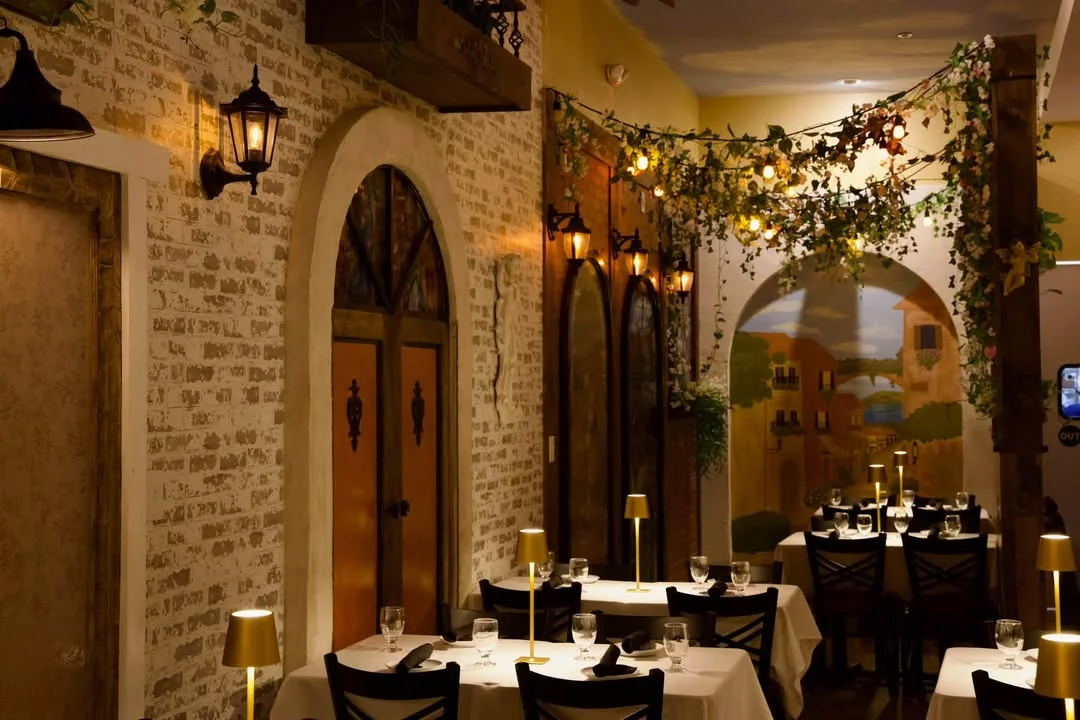 Elegant restaurant dining room with arched doors and warm ambient lighting