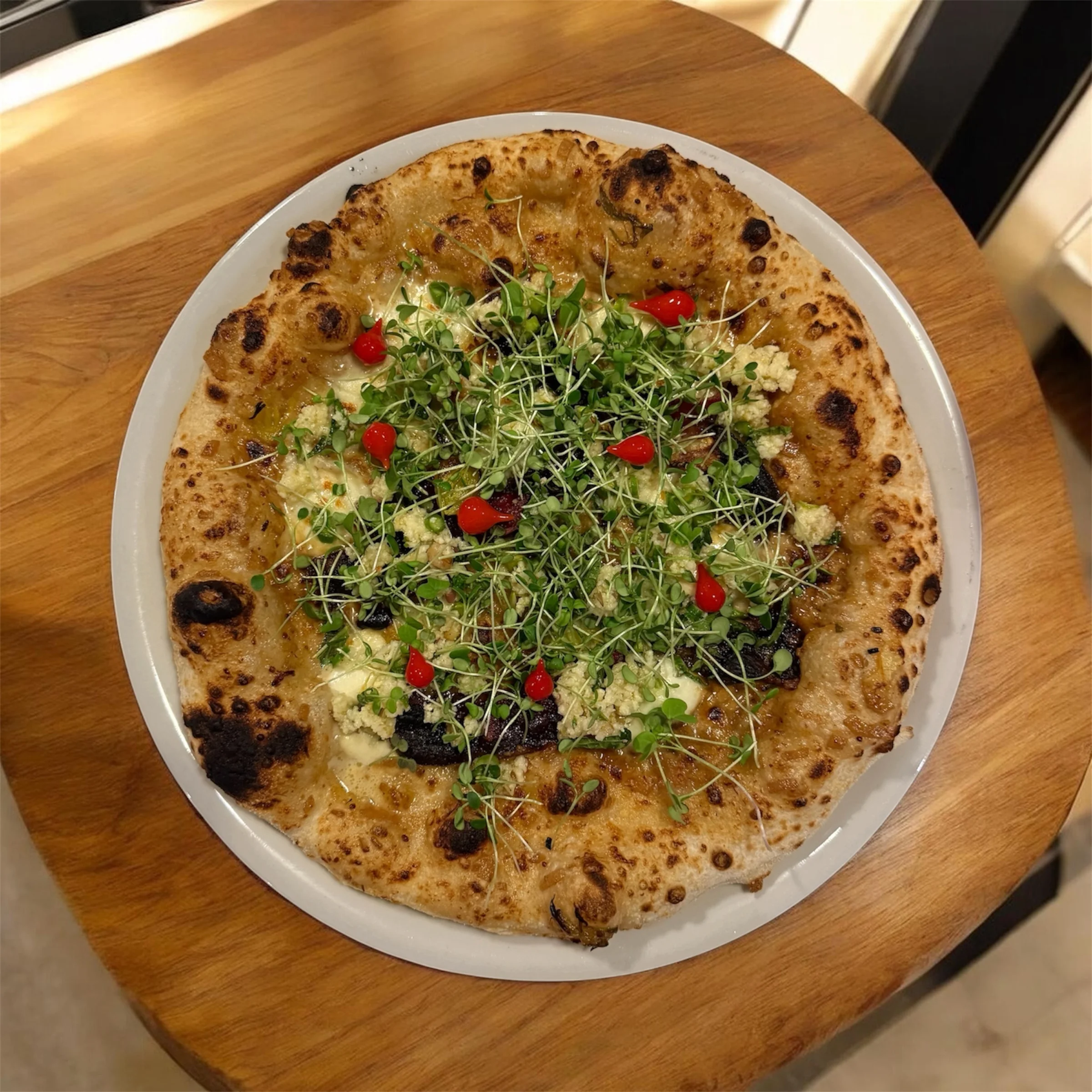 Artisan pizza topped with fresh herbs and cherry tomatoes