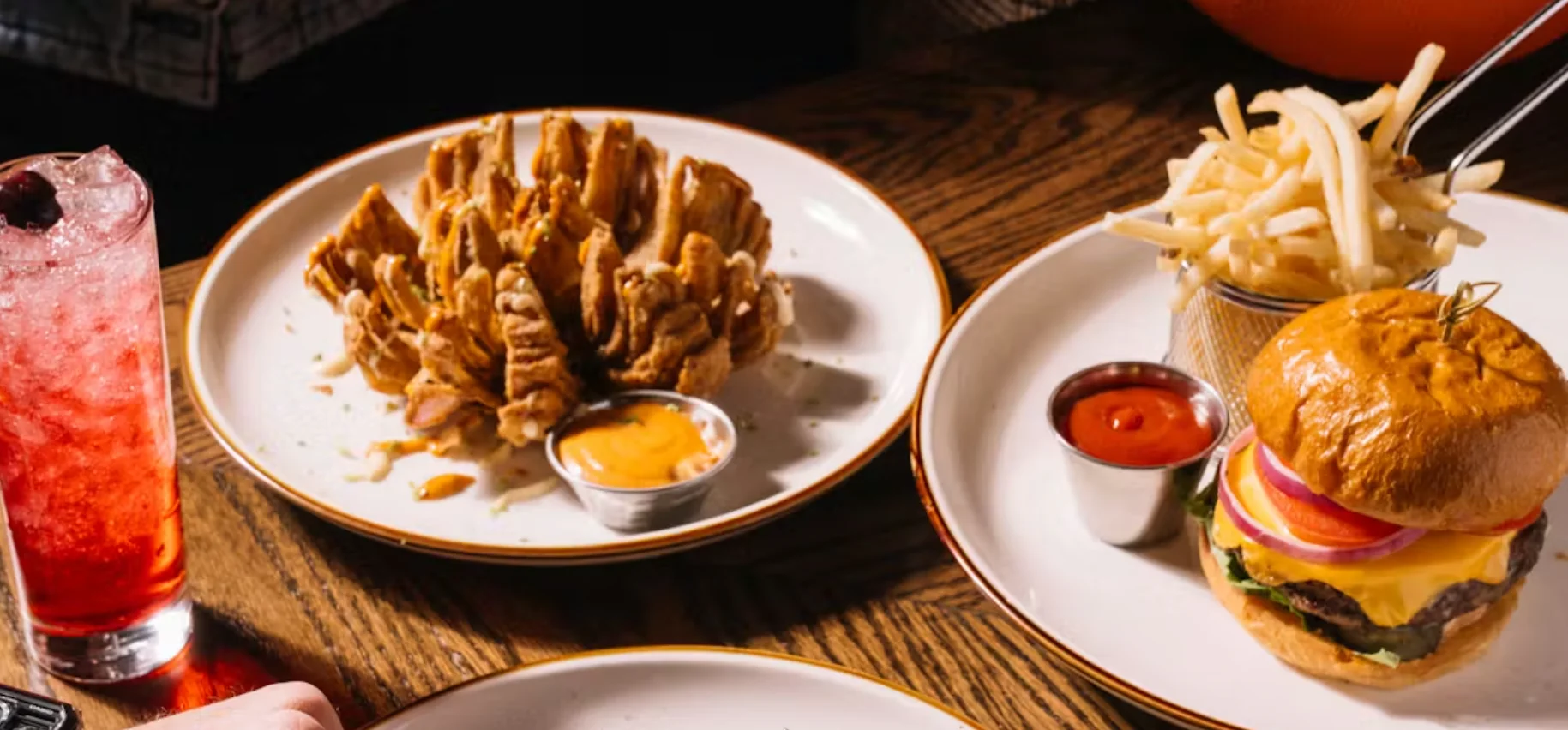 Classic American cheeseburger with fries and blooming onion