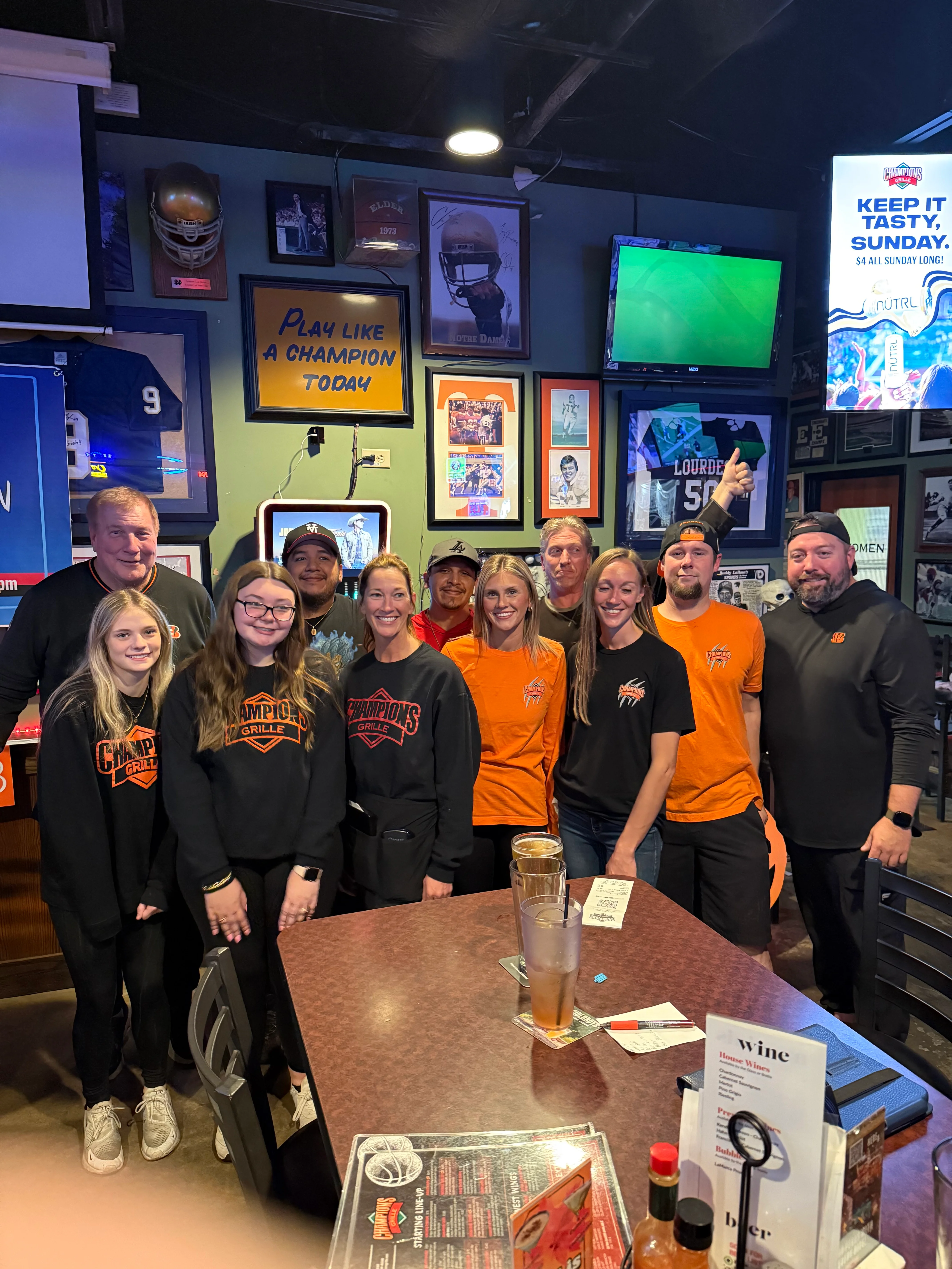 Staff posing in a sports-themed restaurant interior