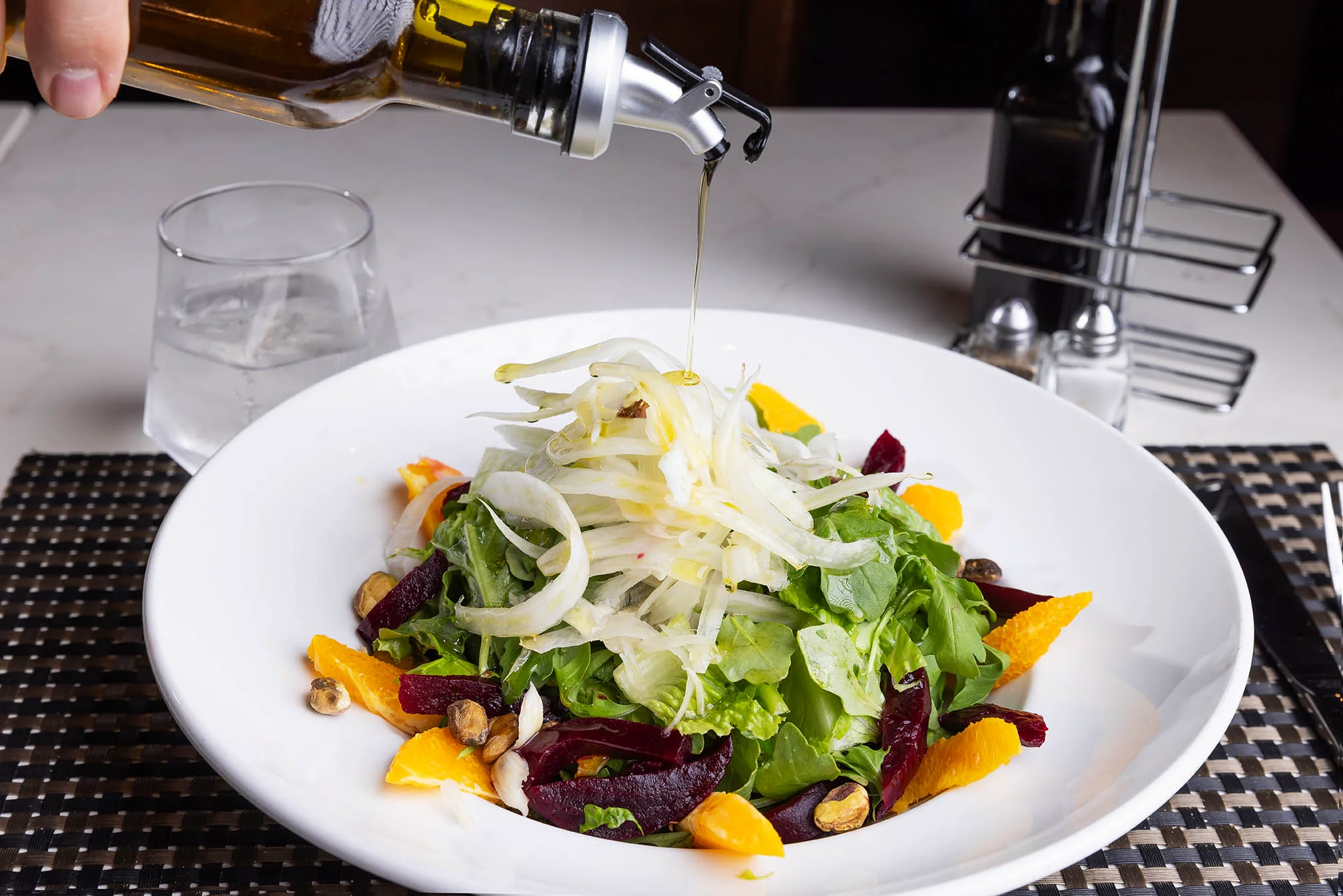Cucina salad being topped with oil