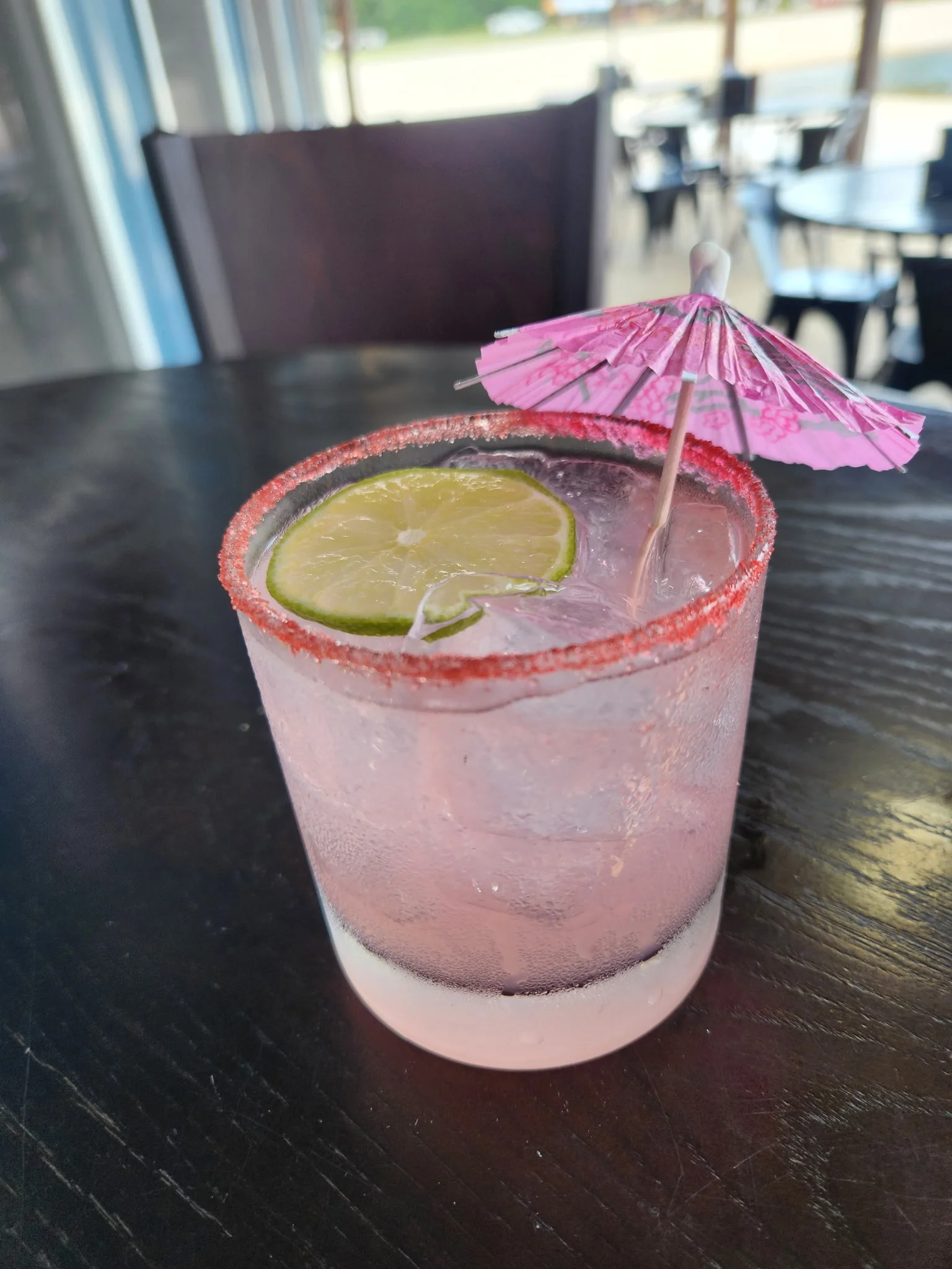 Refreshing pink cocktail with lime and umbrella