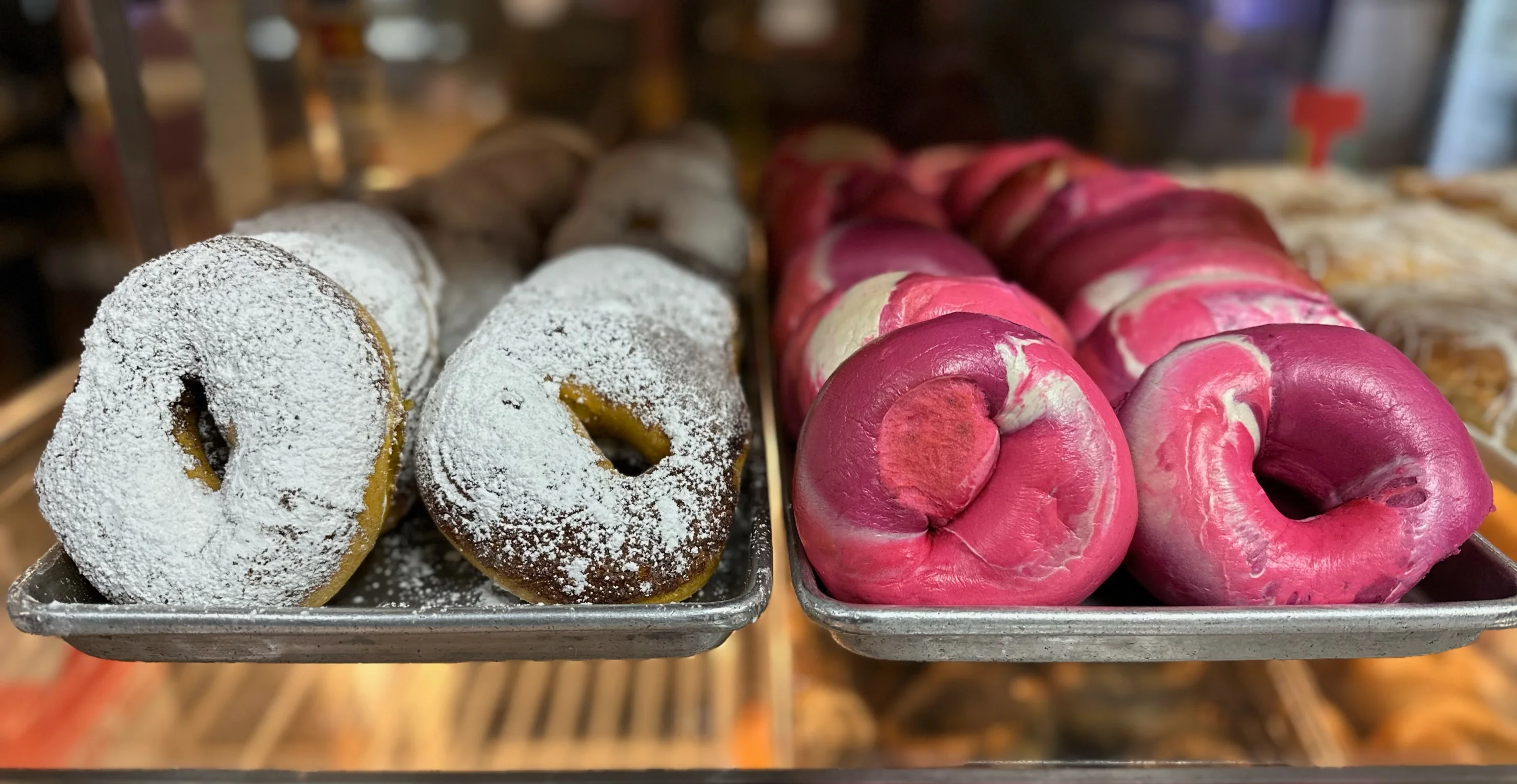 Colorful donuts with powdered sugar and vibrant pink icing