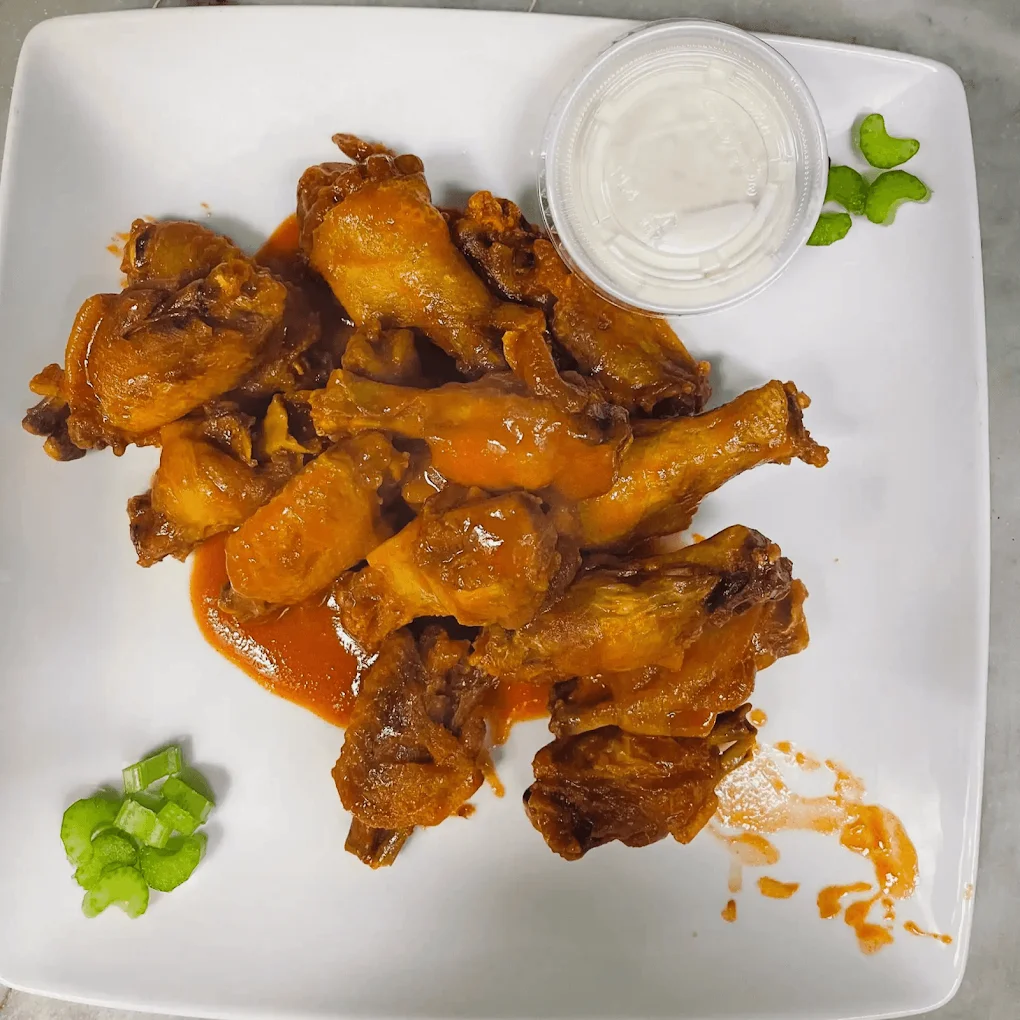 Crispy chicken wings coated in a savory sauce and served with dipping sauce.