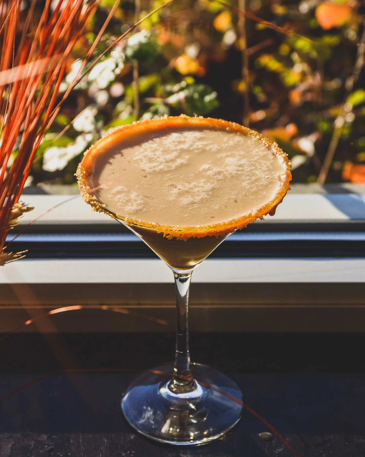 Pecan Pie-Tini on a ledge by fall foliage