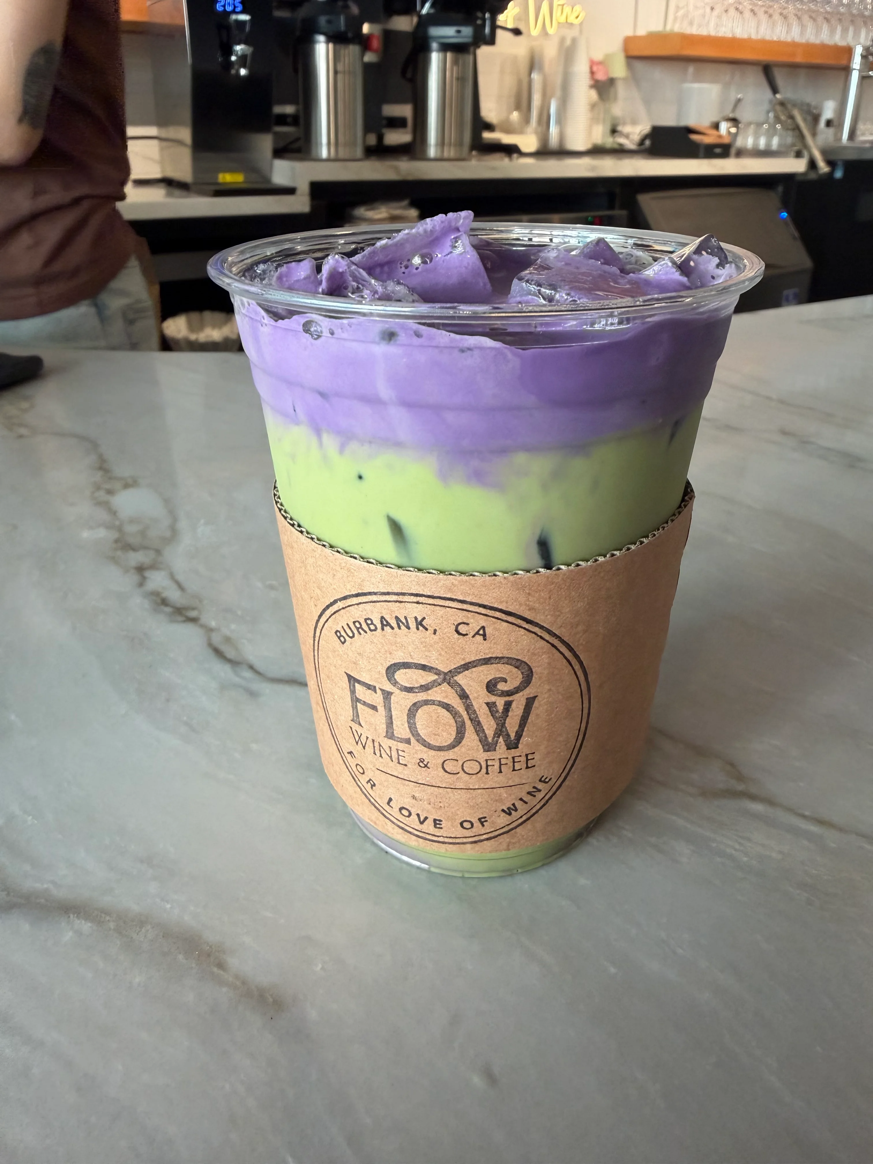 Colorful layered drink with purple and green hues at Flow Wine & Coffee.