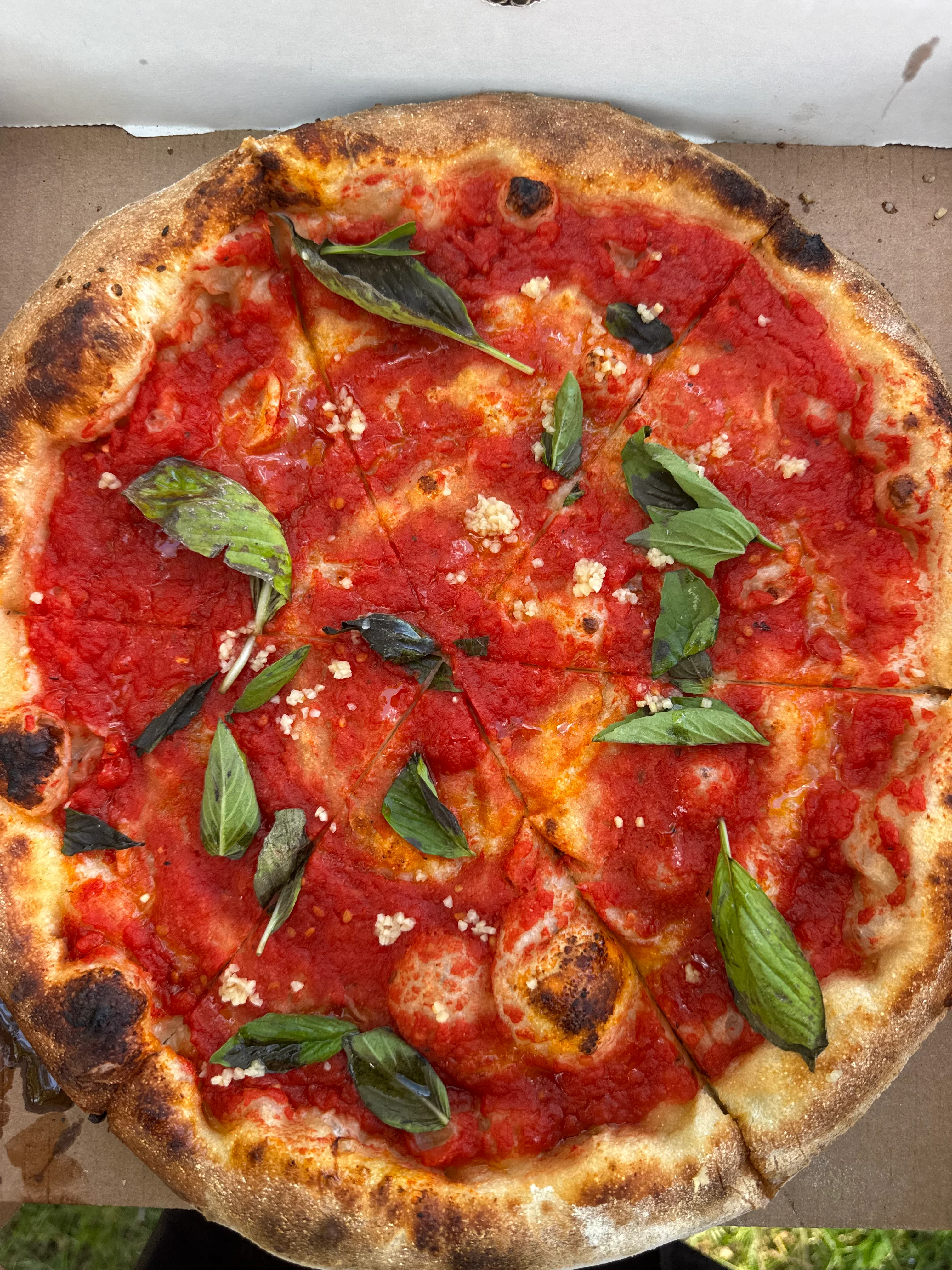 Neapolitan pizza marinara with tomato, garlic, basil, and charred crust