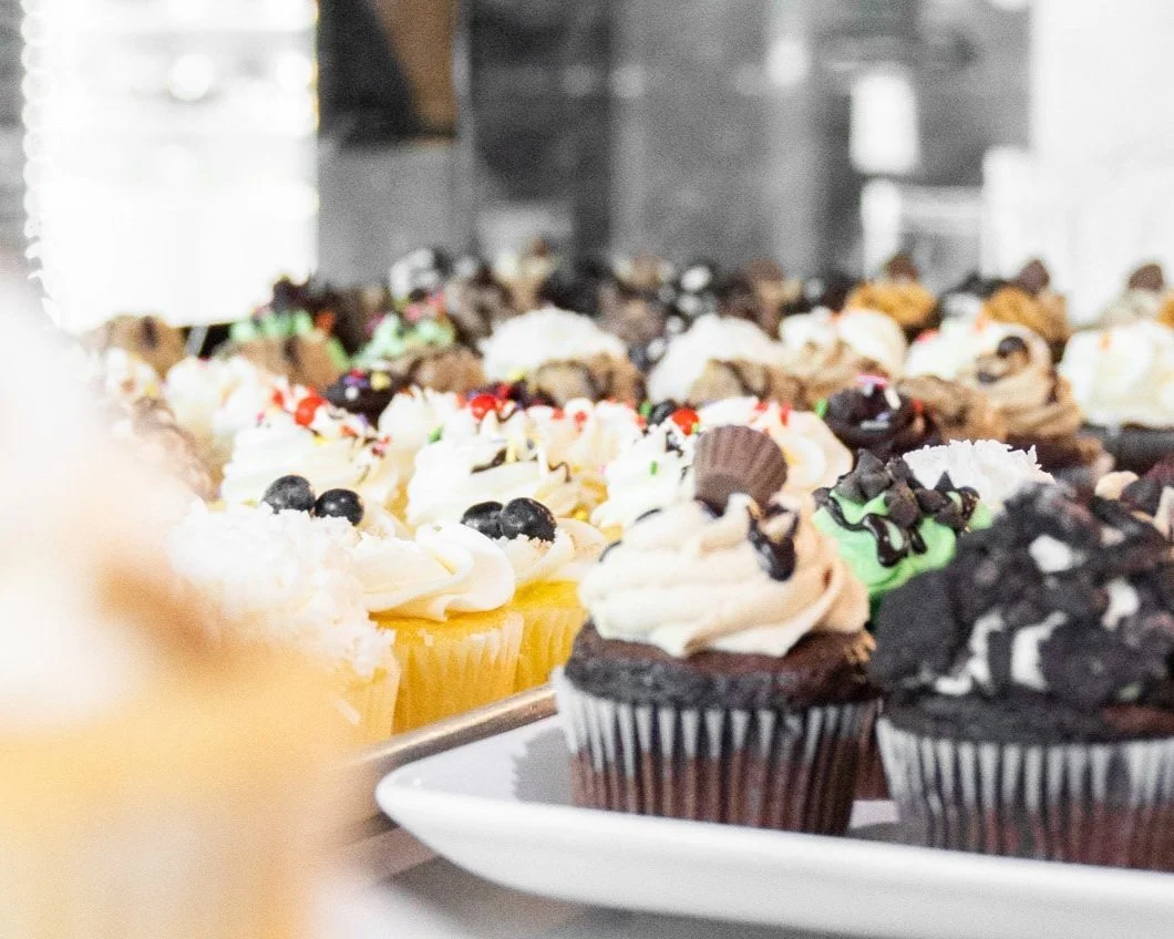 Assorted gourmet cupcakes in a bakery display