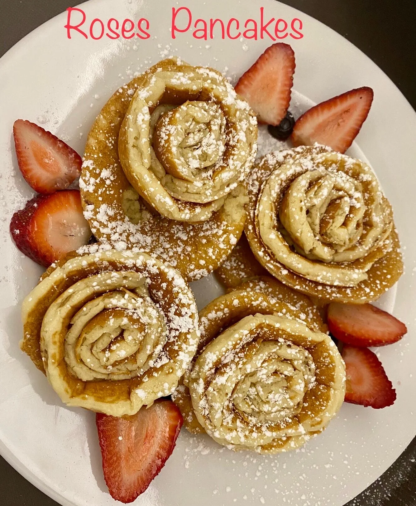 Artistic rose-shaped pancakes served with strawberries