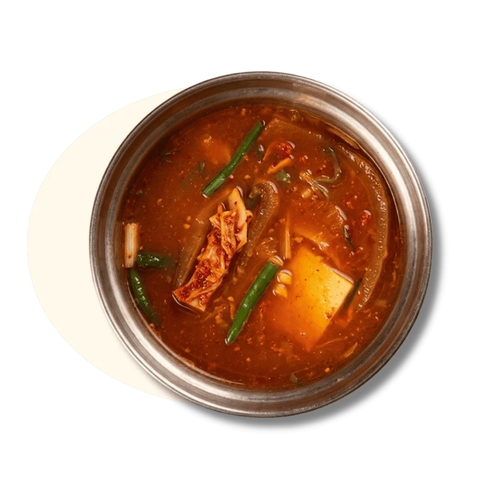 A bowl of spicy soup with vegetables and tofu.