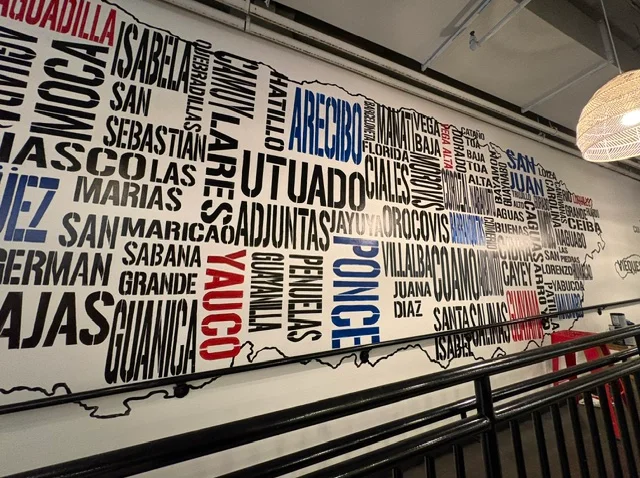 A wall adorned with patterned stone panels featuring inscriptions and symbols representing various concepts.