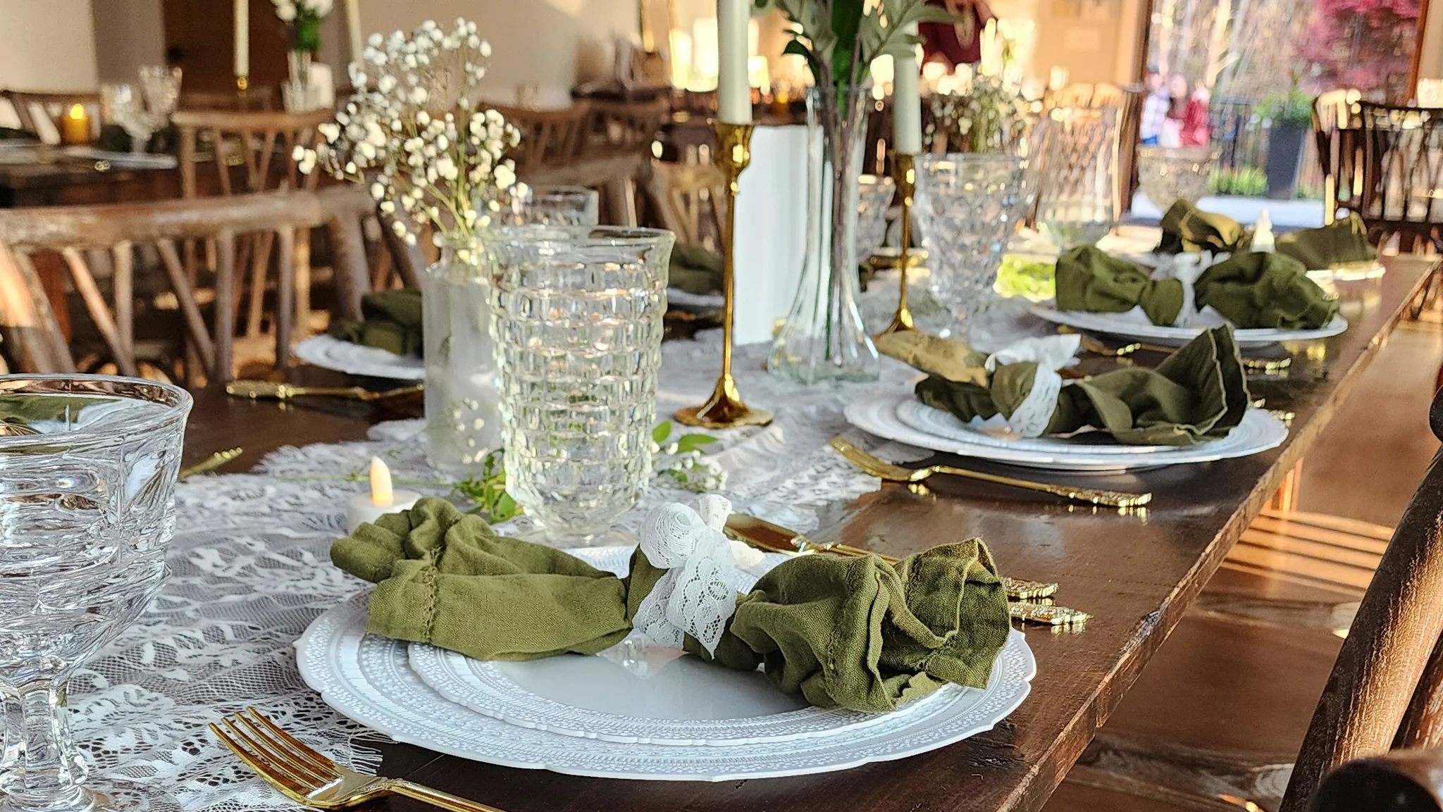 Elegant dining setup with green napkins and floral centerpieces.