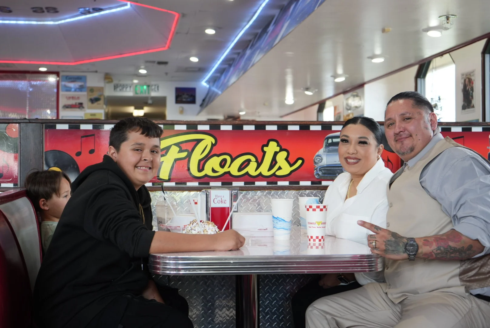 Family enjoying ice cream sundaes in a retro diner