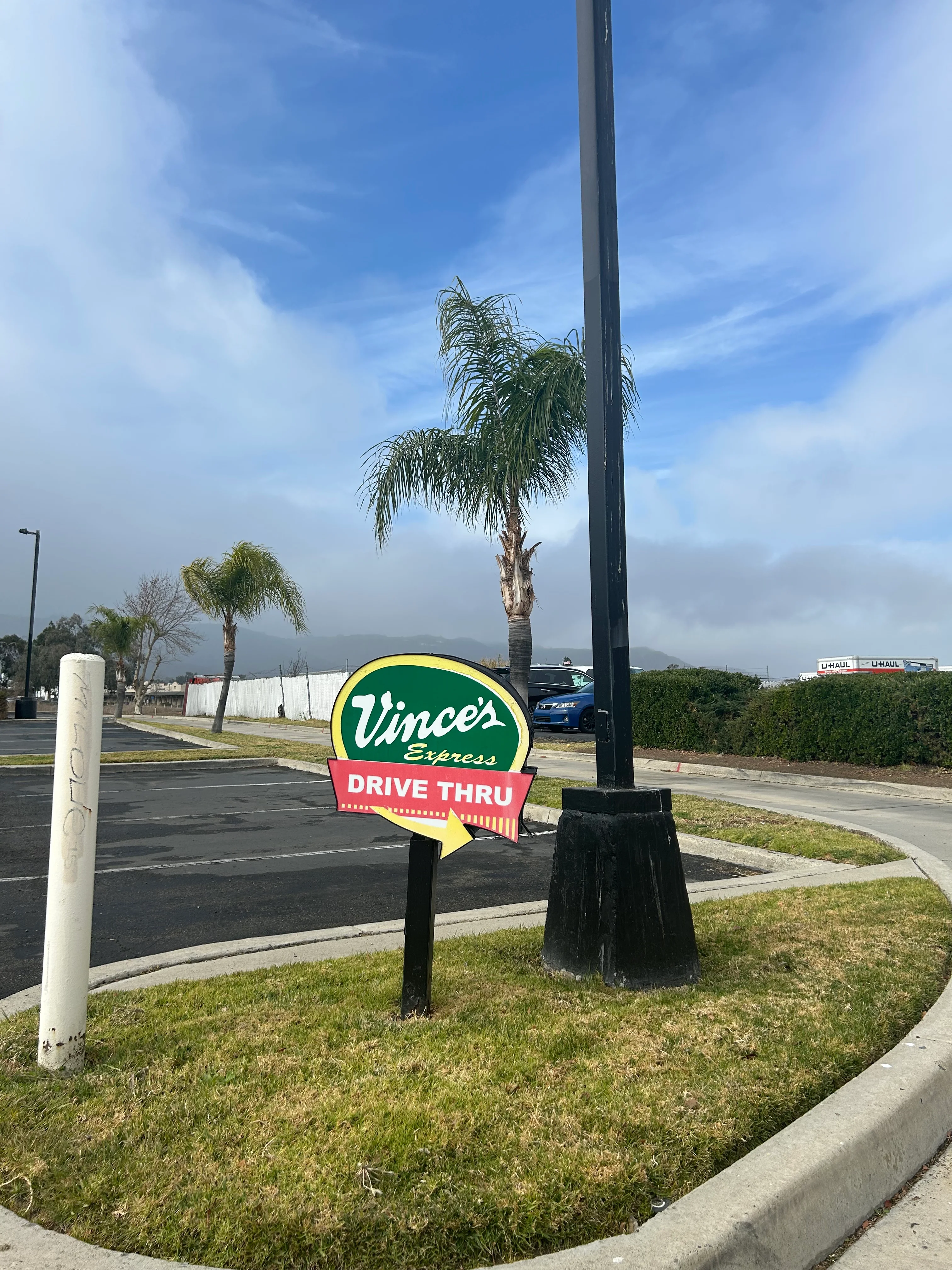 Vince's Express drive-thru restaurant sign beside palm trees