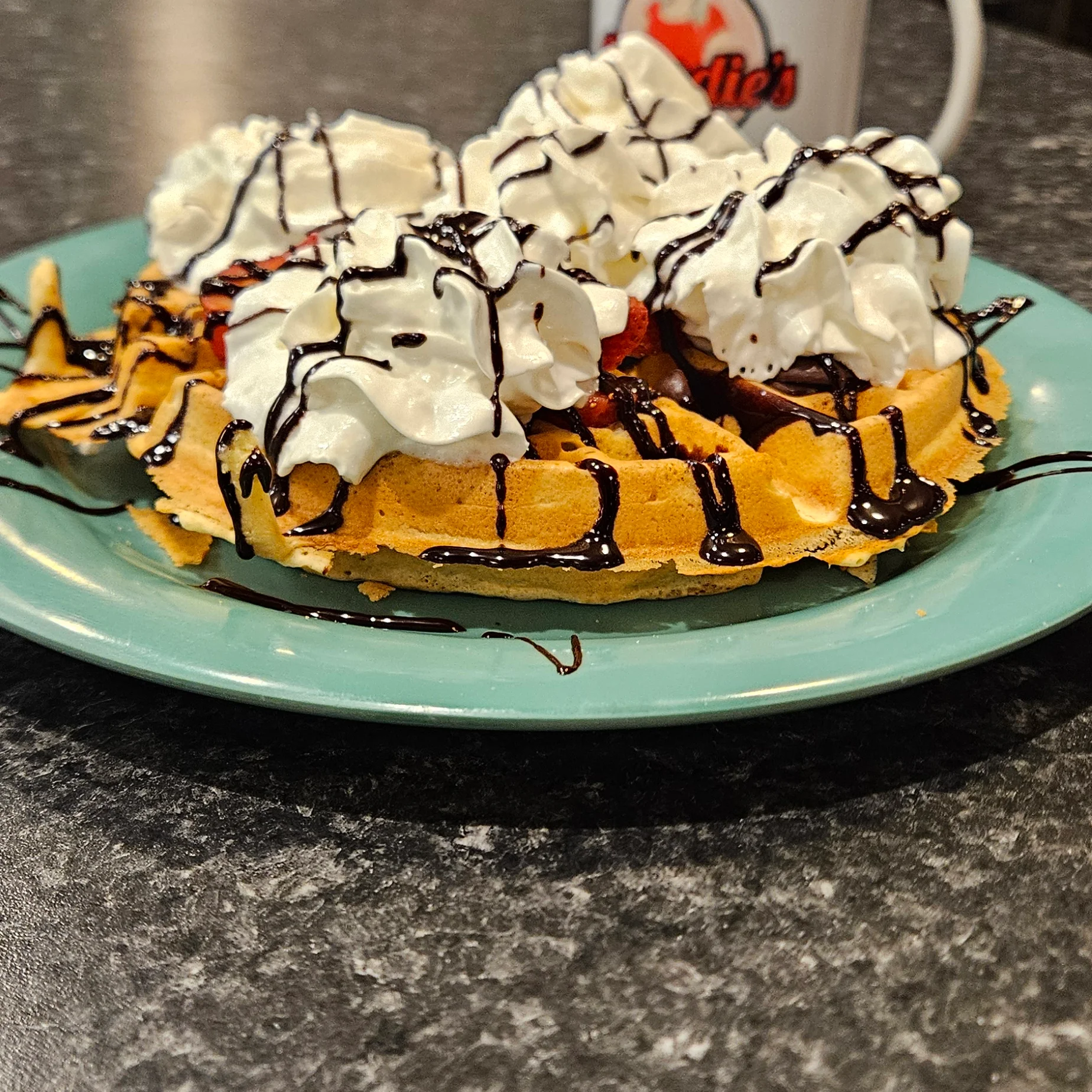 Delicious Belgian waffles topped with whipped cream and chocolate drizzle