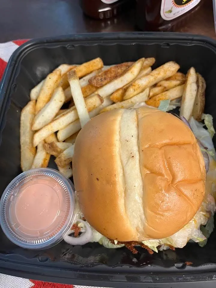 Classic American cheeseburger with fries and dipping sauce