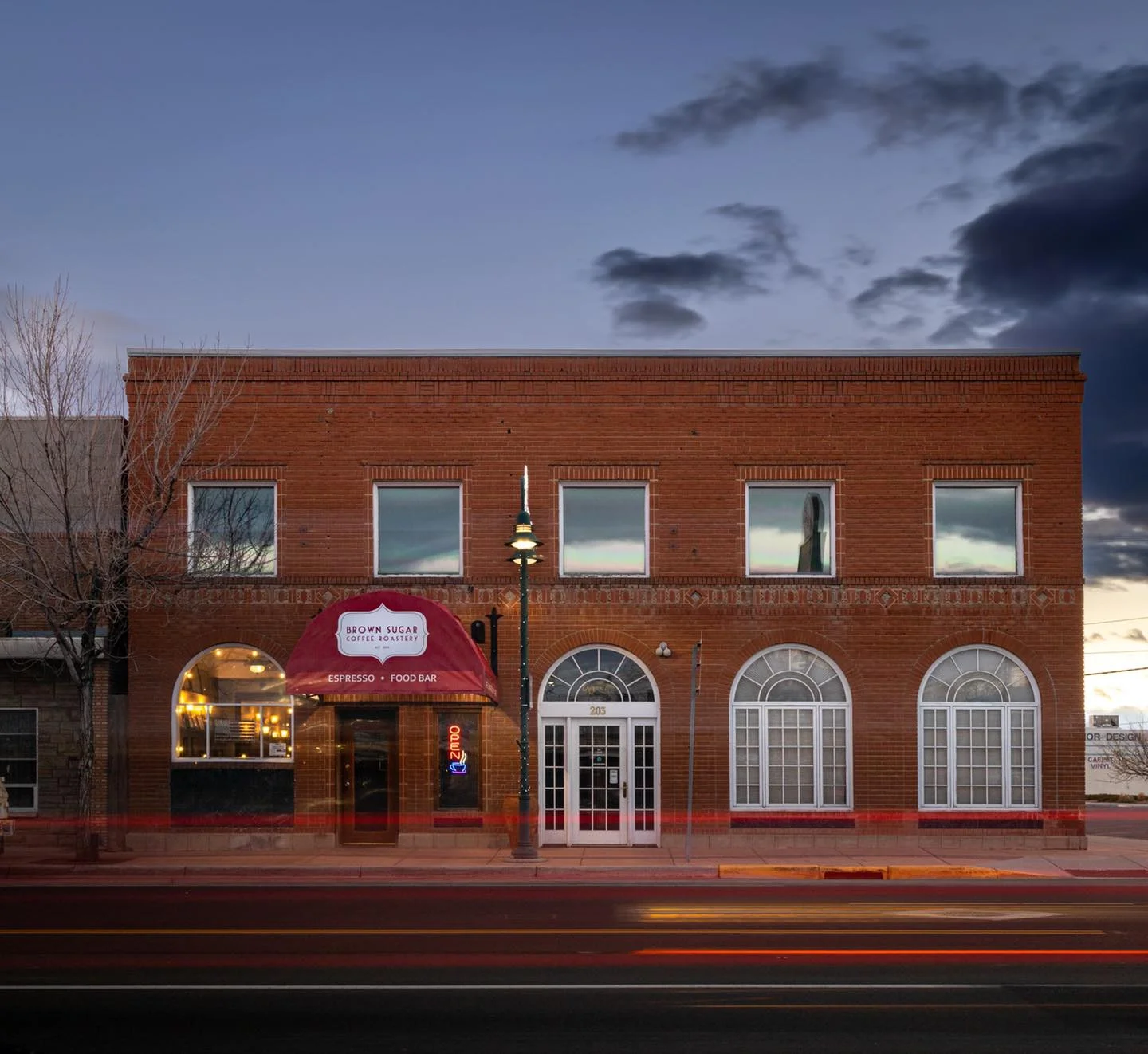 Charming coffee shop exterior with red awning and warm lighting