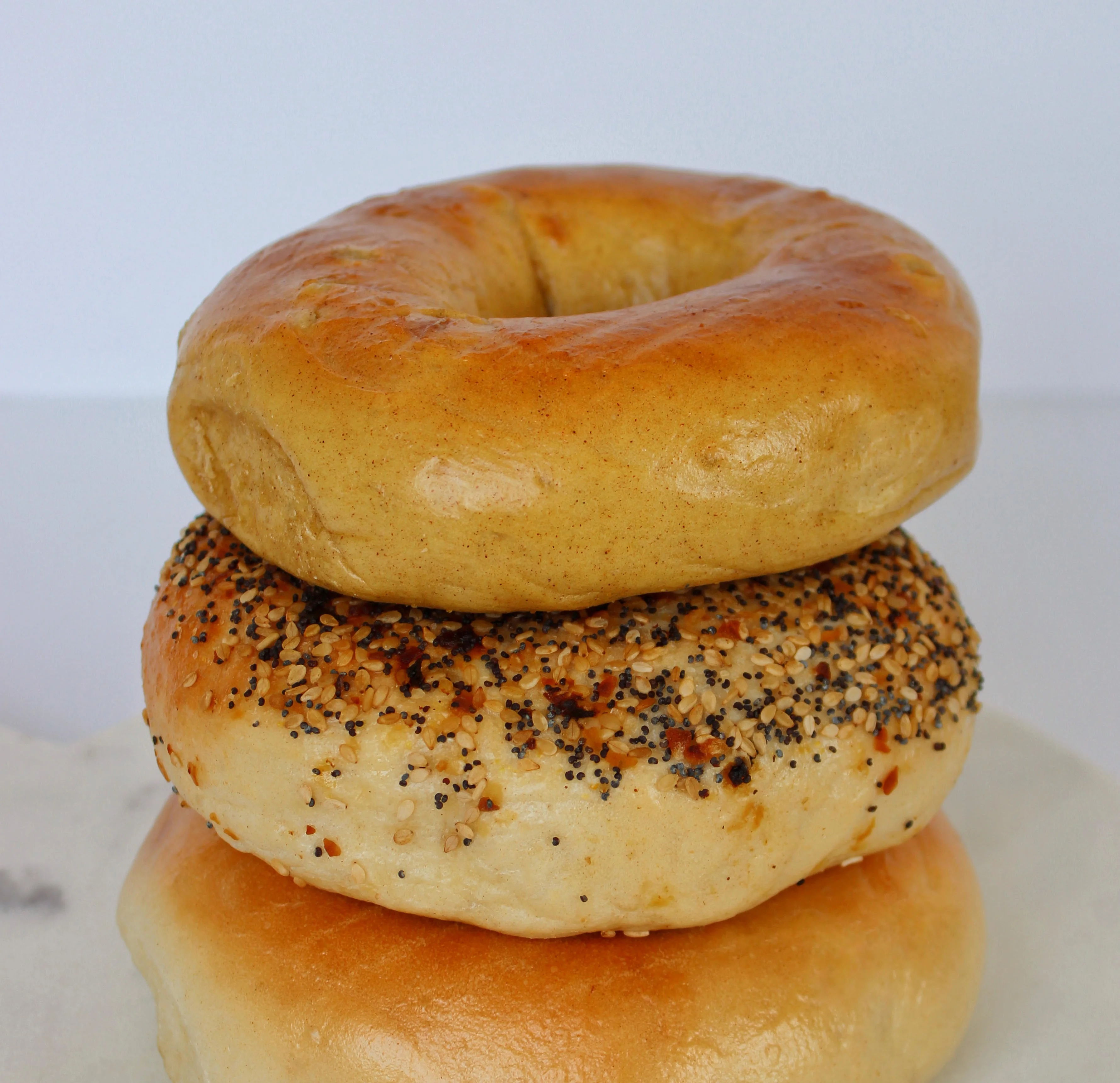 A variety of freshly baked bagels displayed on a wooden board.