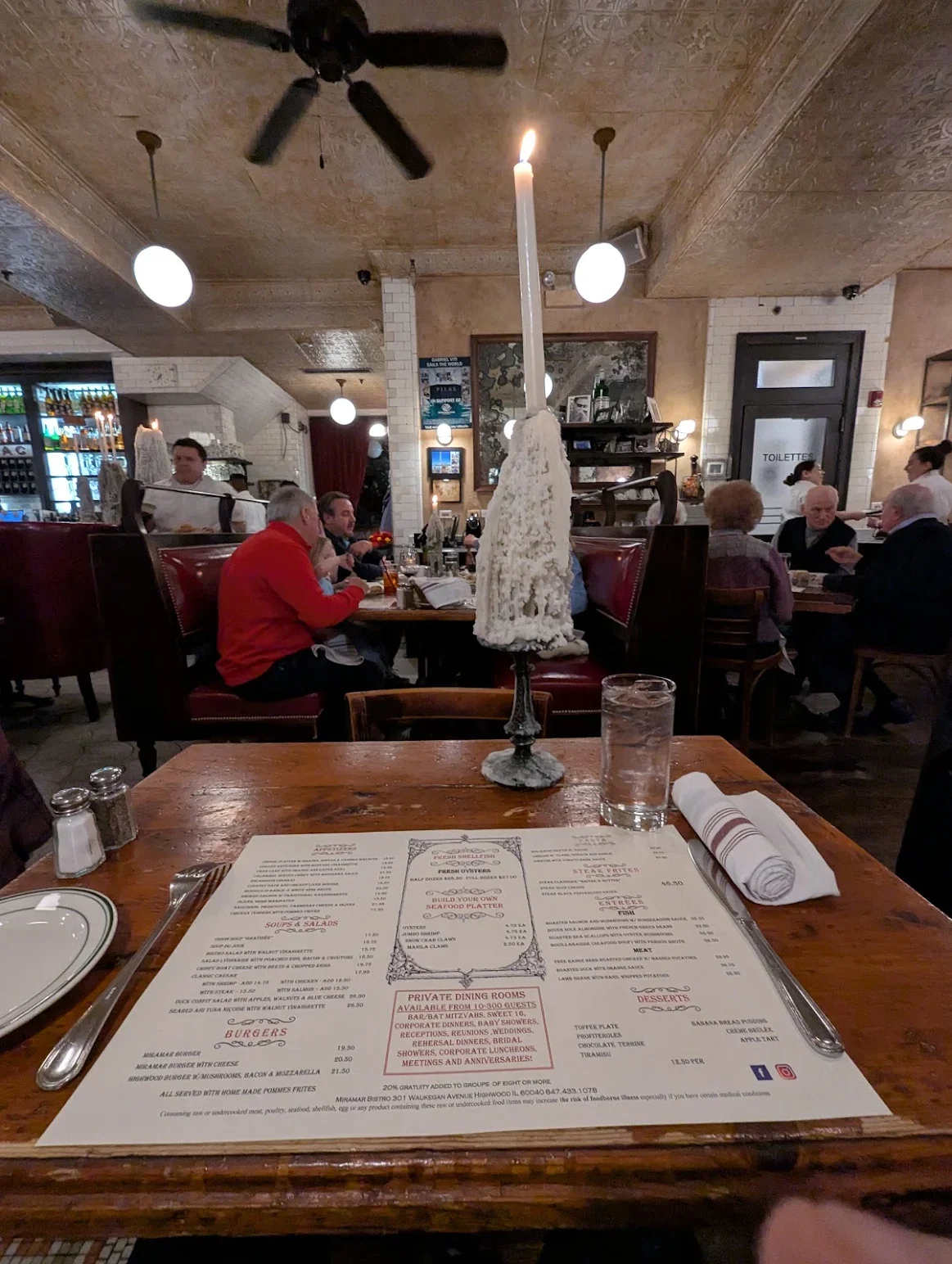 Cozy restaurant interior with a candlelit table and menu on a wooden surface