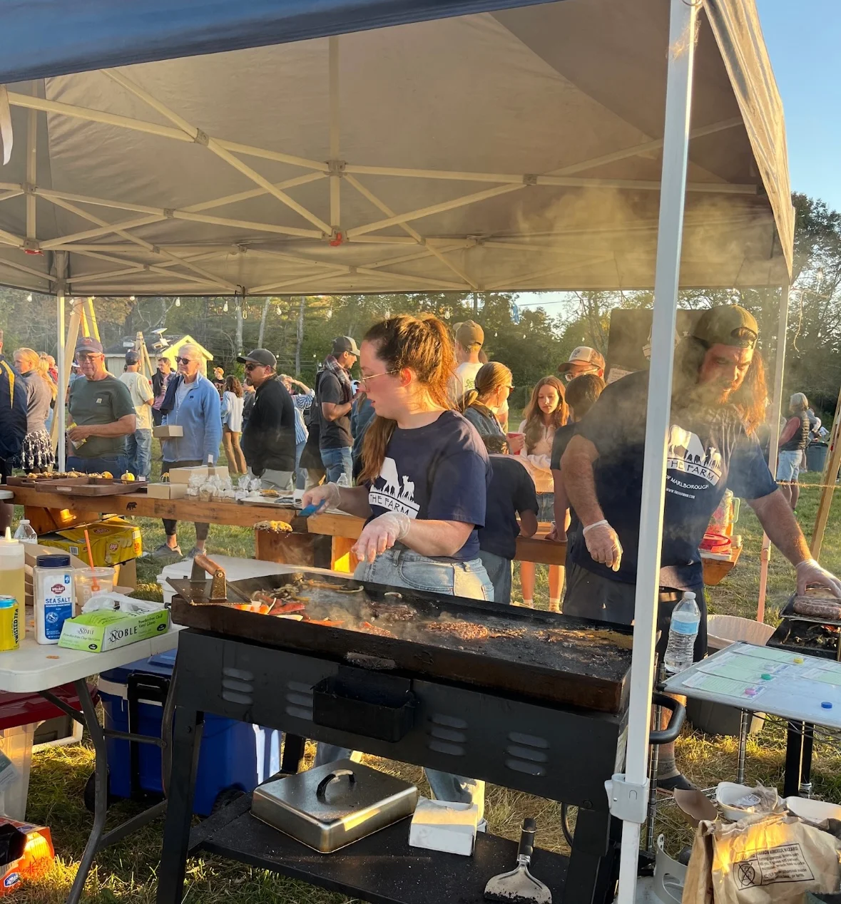 Grilling burgers at a lively outdoor food festival
