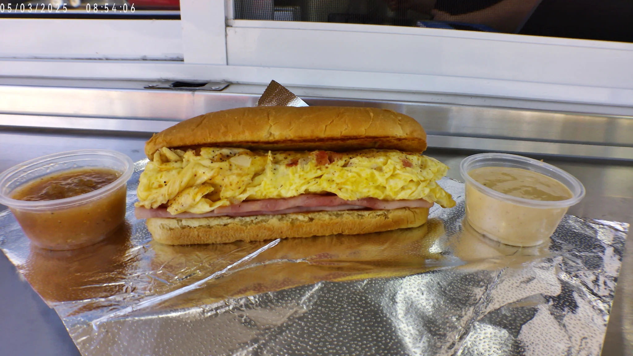 Breakfast sandwich with scrambled eggs and ham on a soft bun