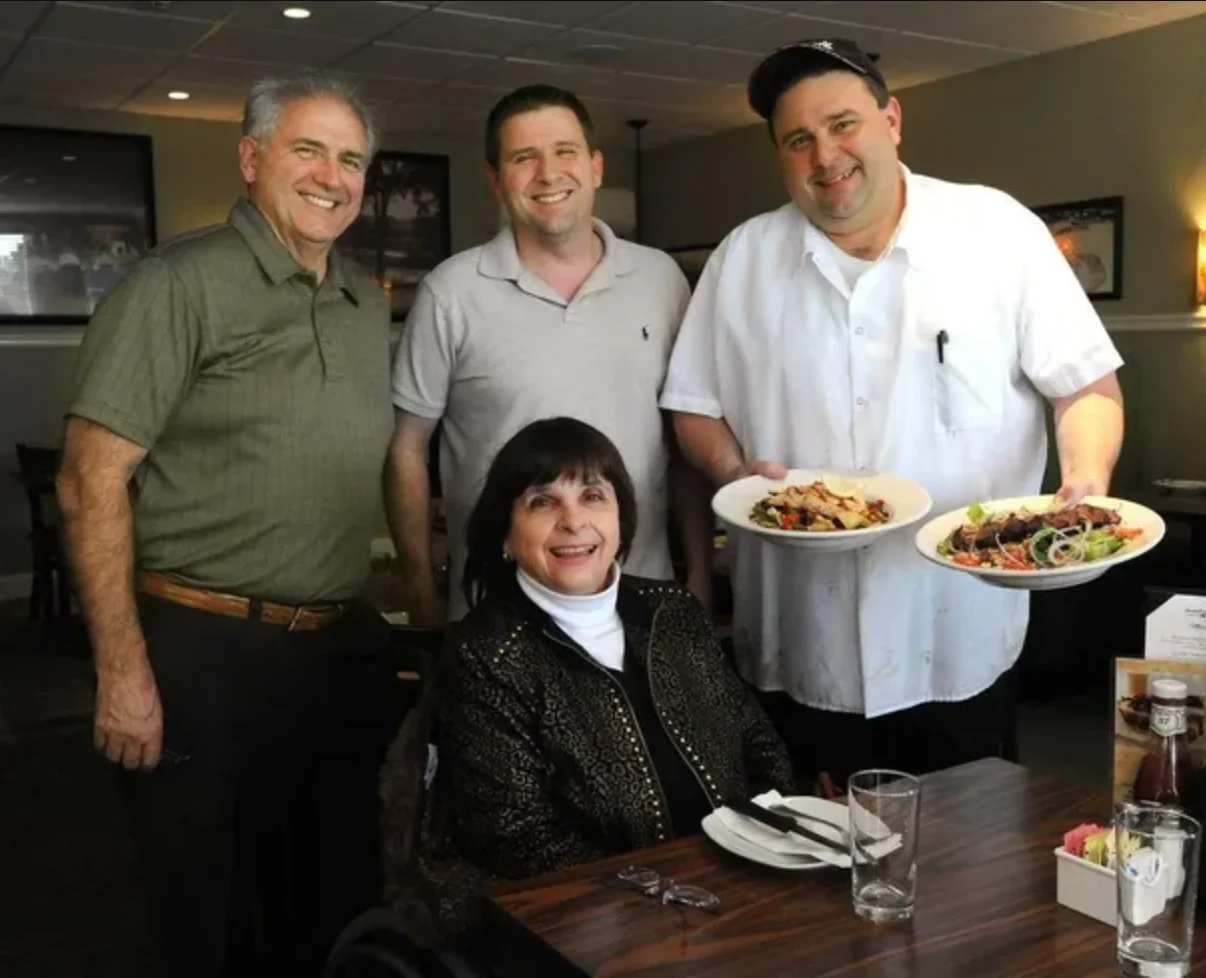 Chefs presenting Italian pasta dishes in a cozy restaurant setting