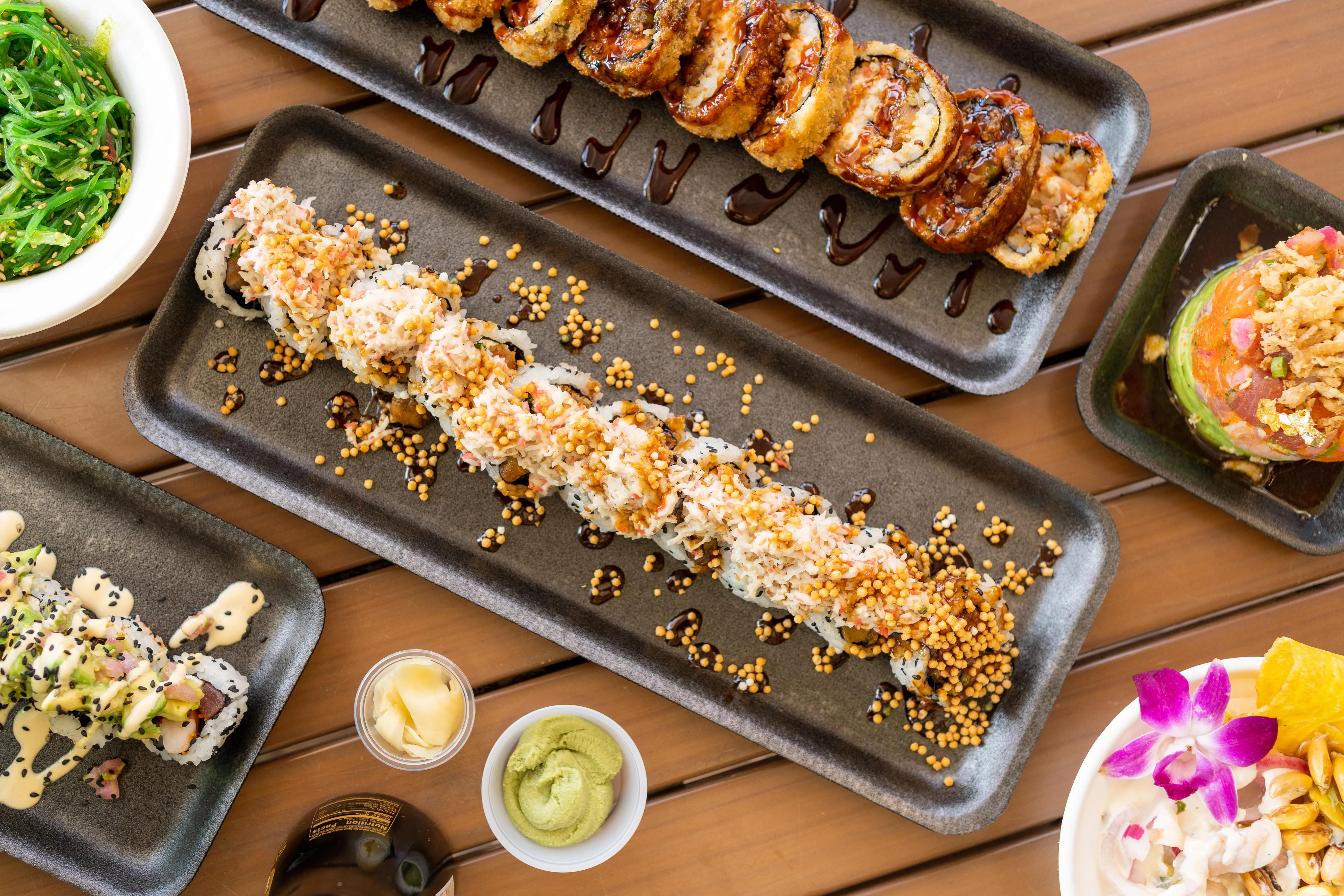 Assorted sushi rolls and appetizers on a wooden table
