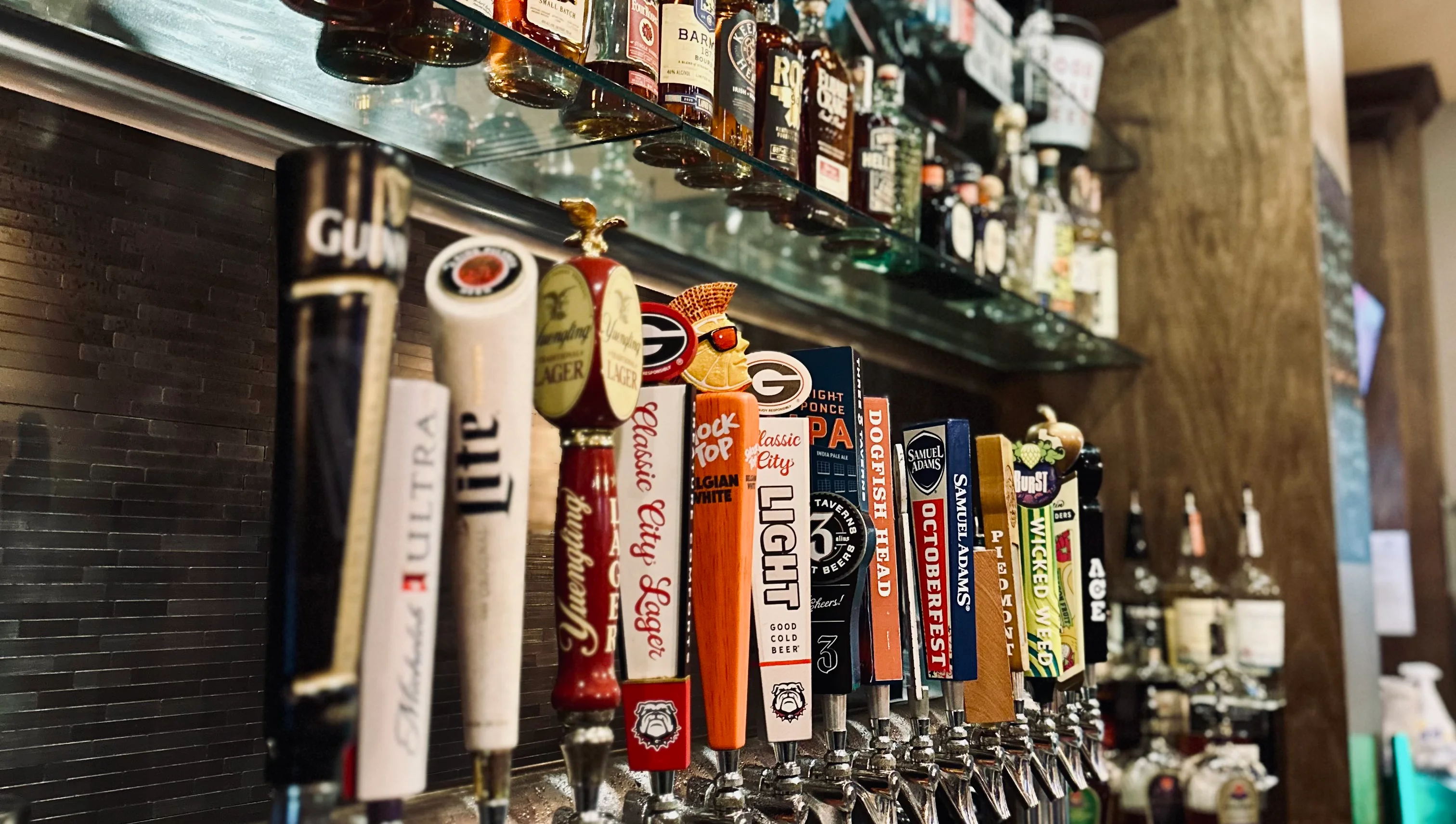 Well-stocked bar with various liquor bottles and draft beer taps