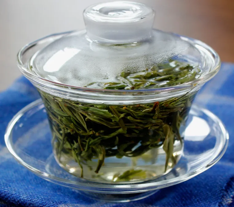 Brewing green tea in a glass teapot