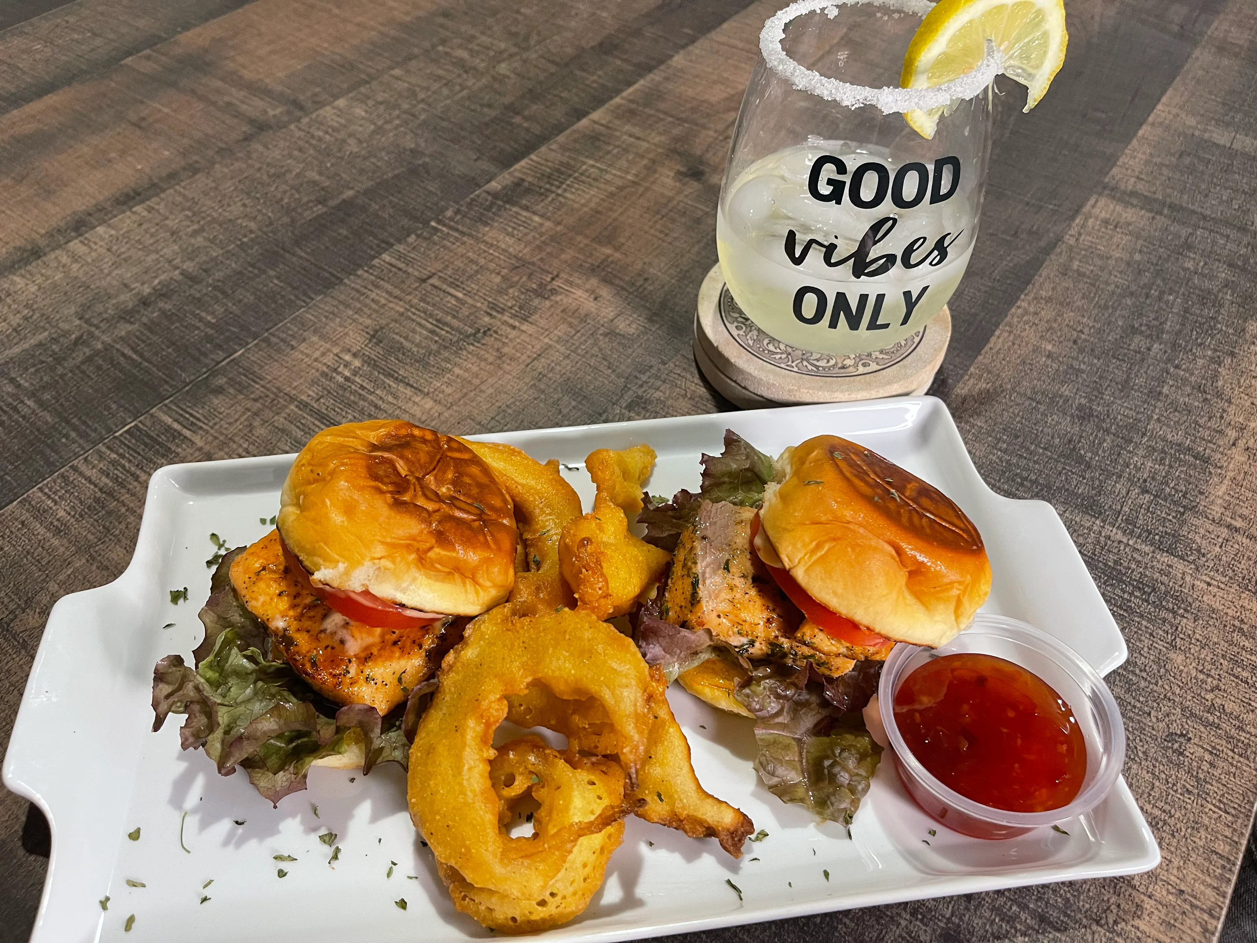 Grilled salmon sliders with onion rings and a refreshing cocktail