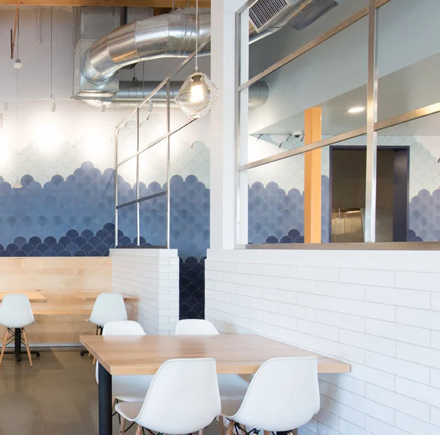 Modern restaurant interior with blue wave mural