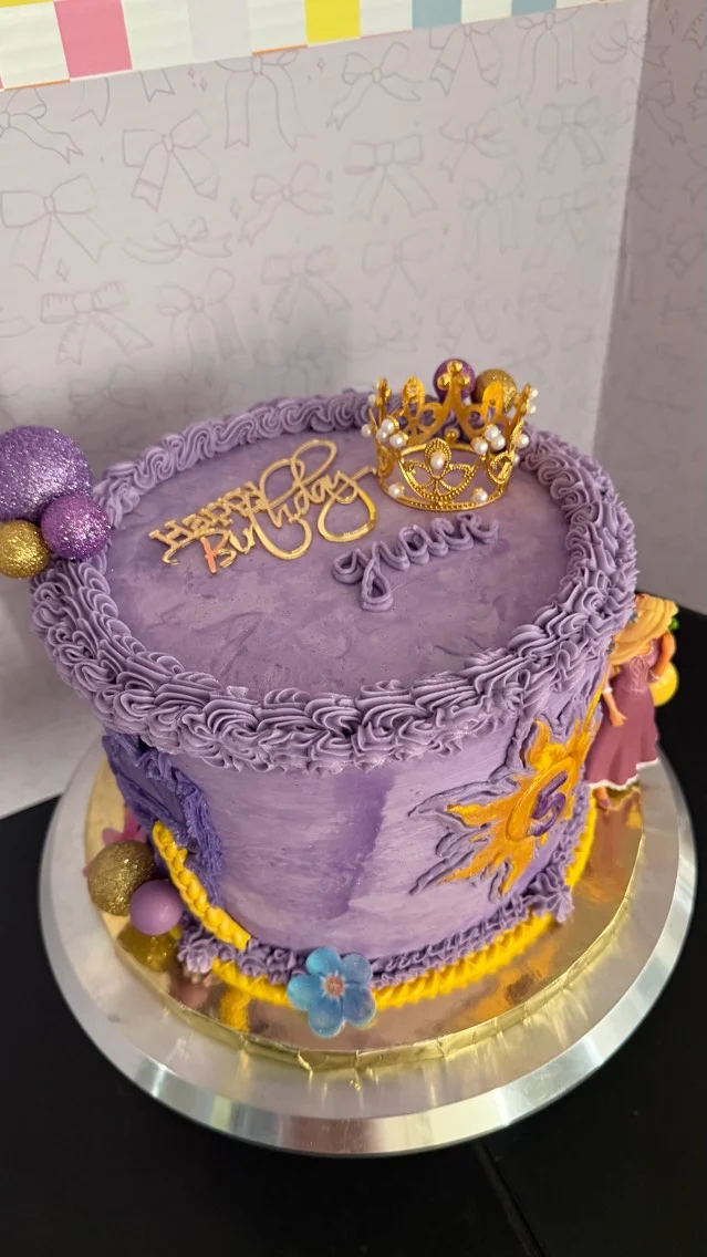 Purple birthday cake with crown and decorative elements