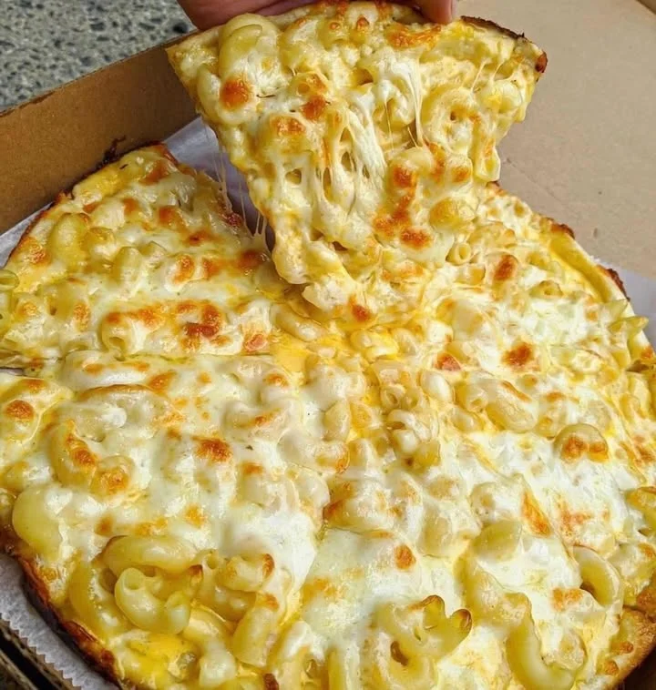 A cheesy pizza topped with macaroni pasta, showcasing a golden, melted cheese layer.