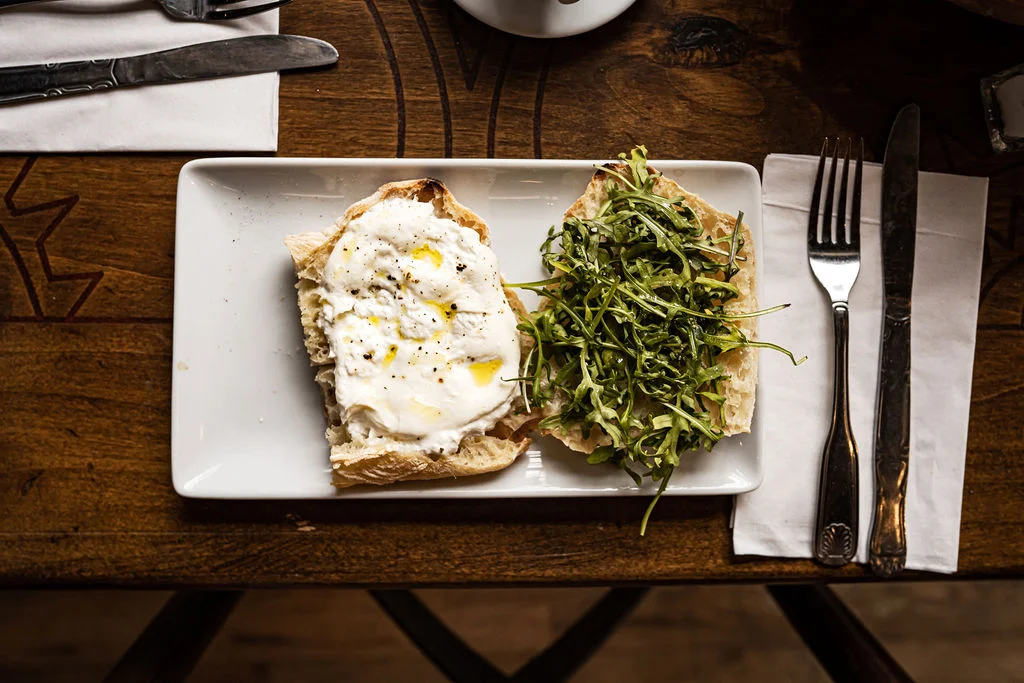 Breakfast sandwich on fresh baked ciabbiata with olive oil fried egg arugula sea salt lemon