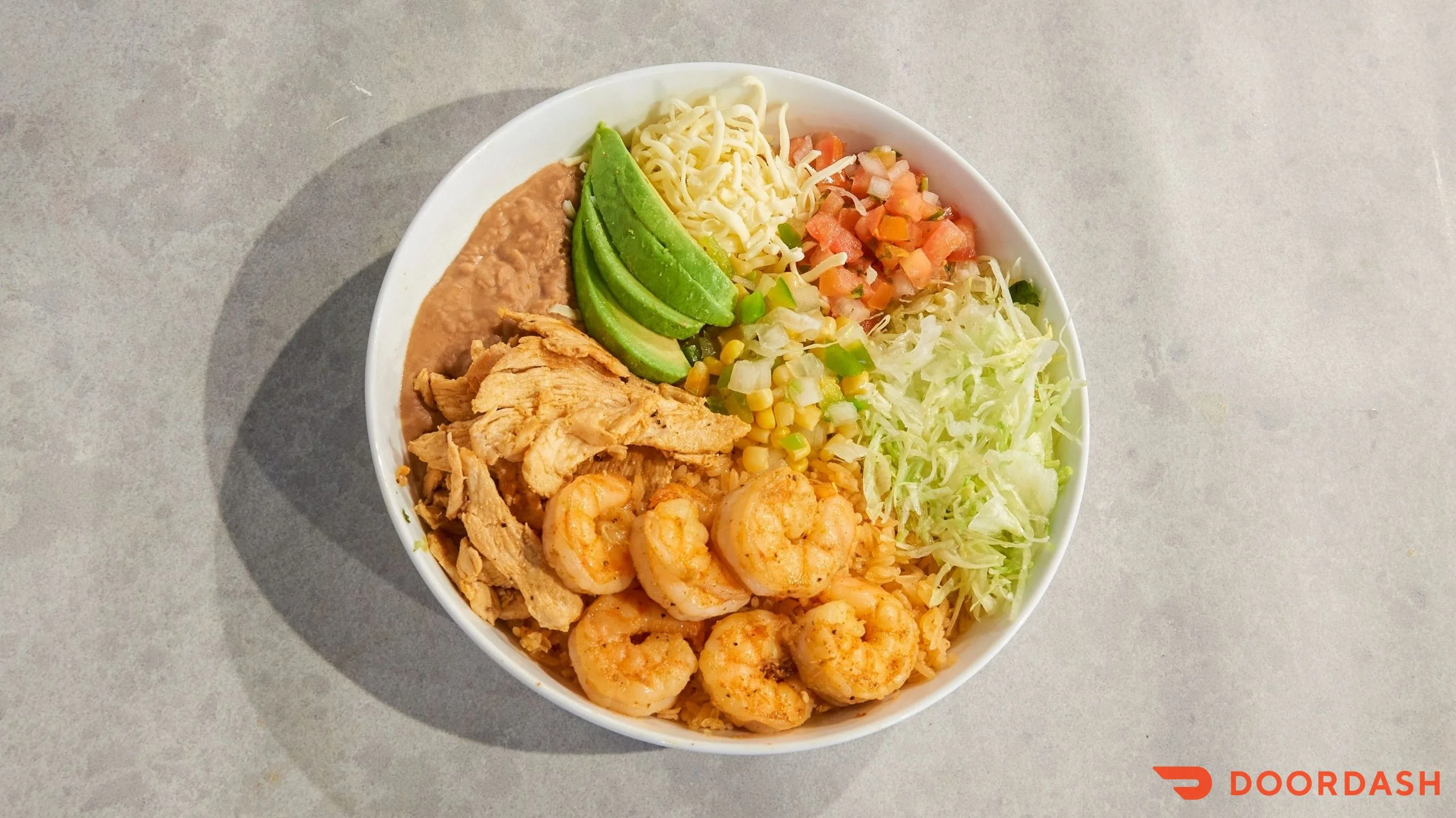 Mexican shrimp and chicken rice bowl with fresh toppings