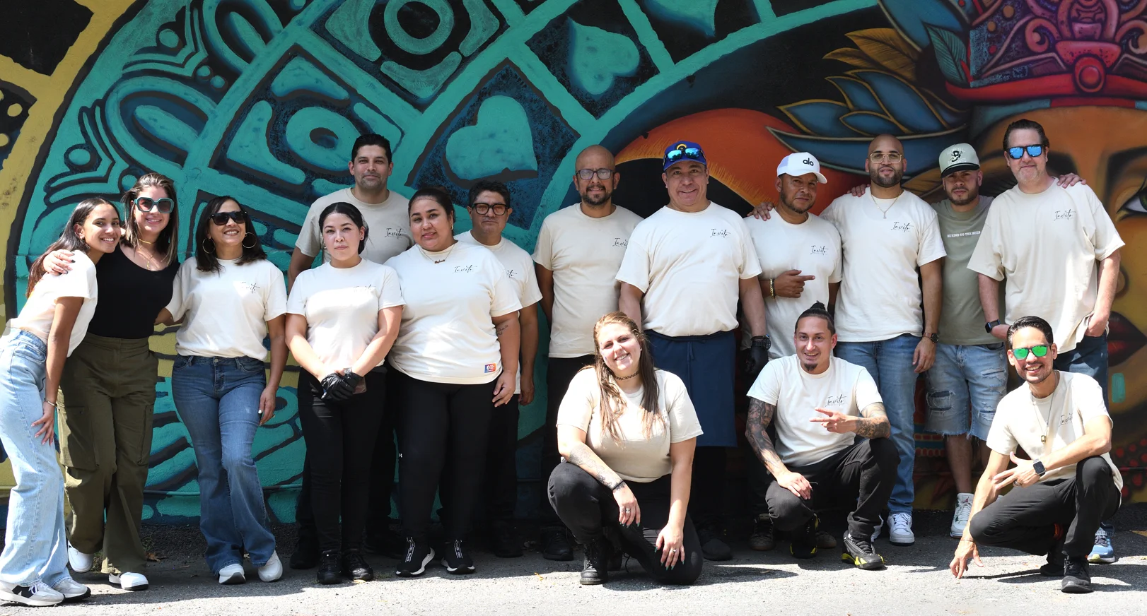 Team photo in front of a colorful mural