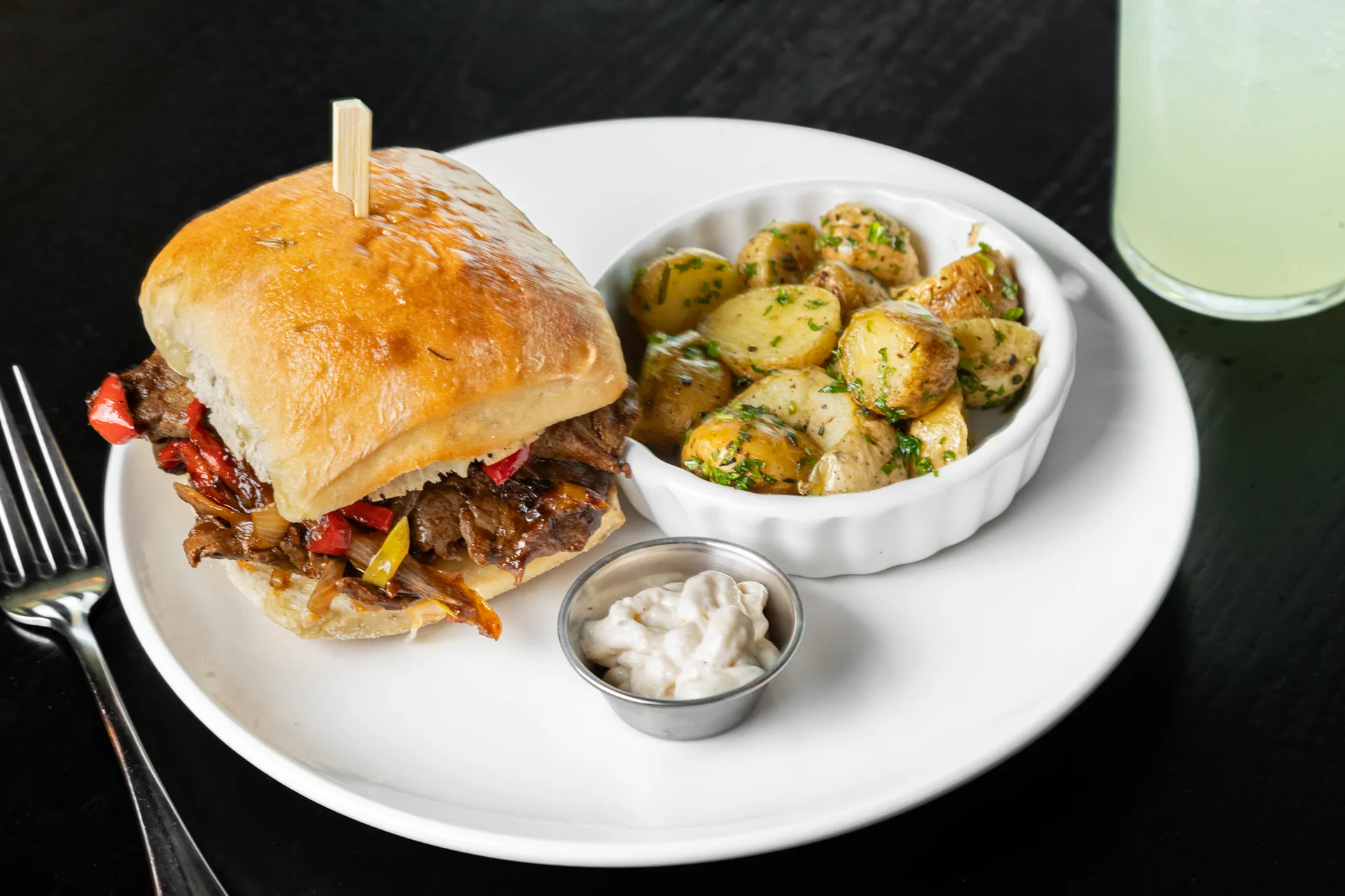 Philly cheesesteak sandwich with roasted potatoes