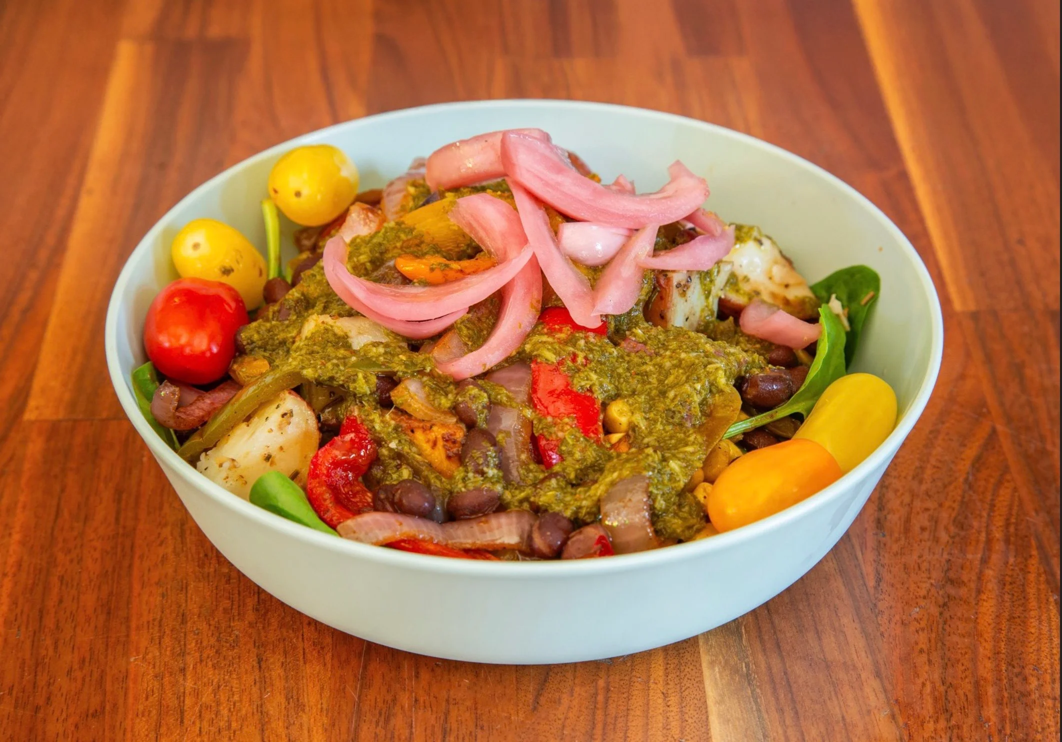 Vibrant Mexican-style salad bowl with fresh vegetables and green sauce